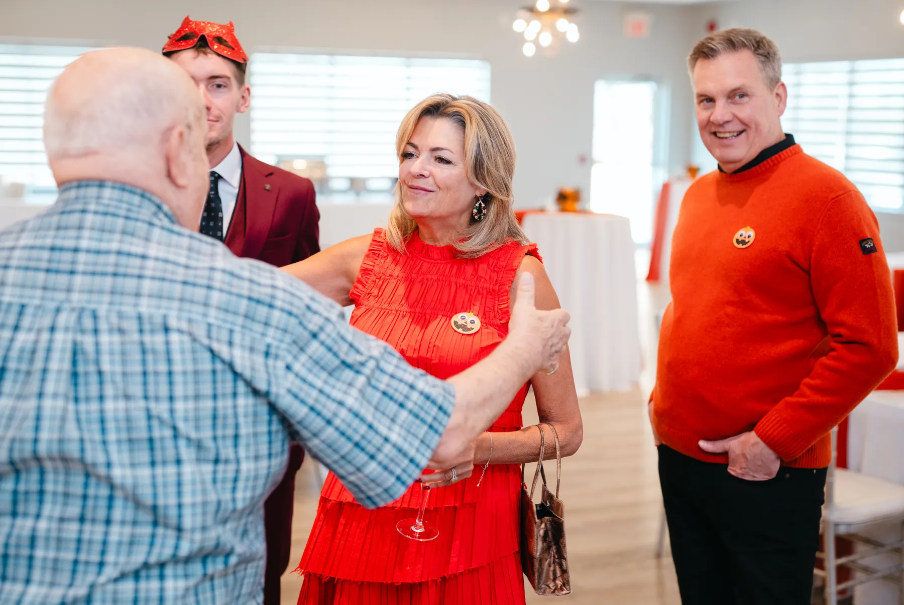 Costumed guests greeting and hugging indoors at Jenna and Jake’s Halloween party.