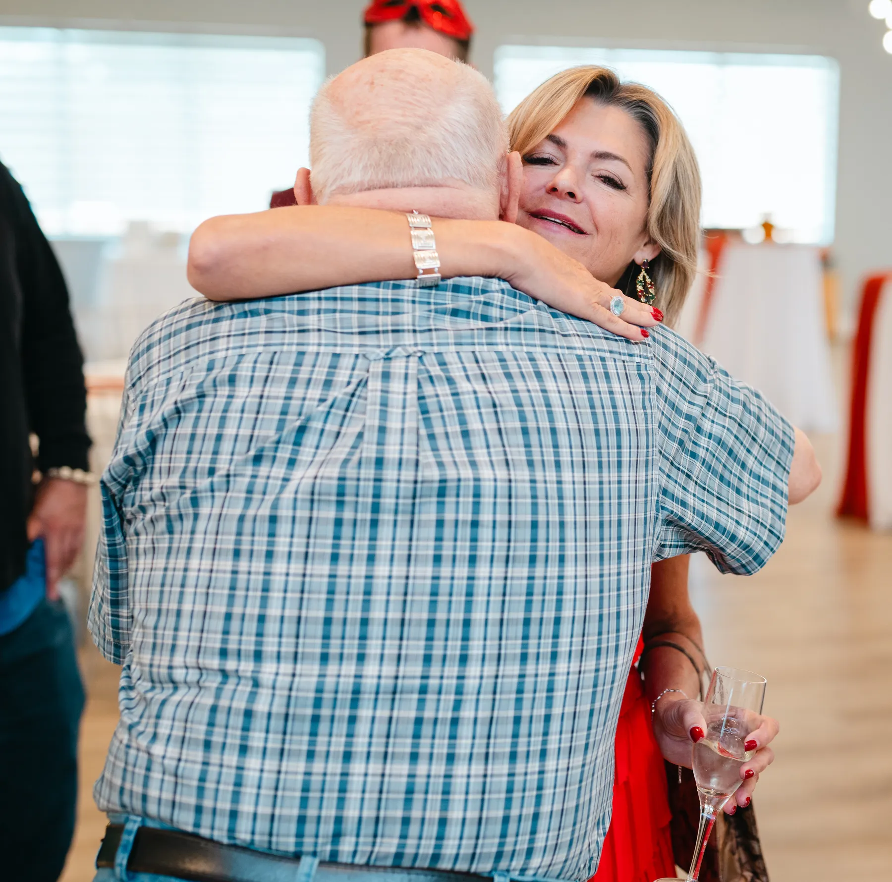 Costumed guests greeting and hugging indoors at Jenna and Jake’s Halloween party.