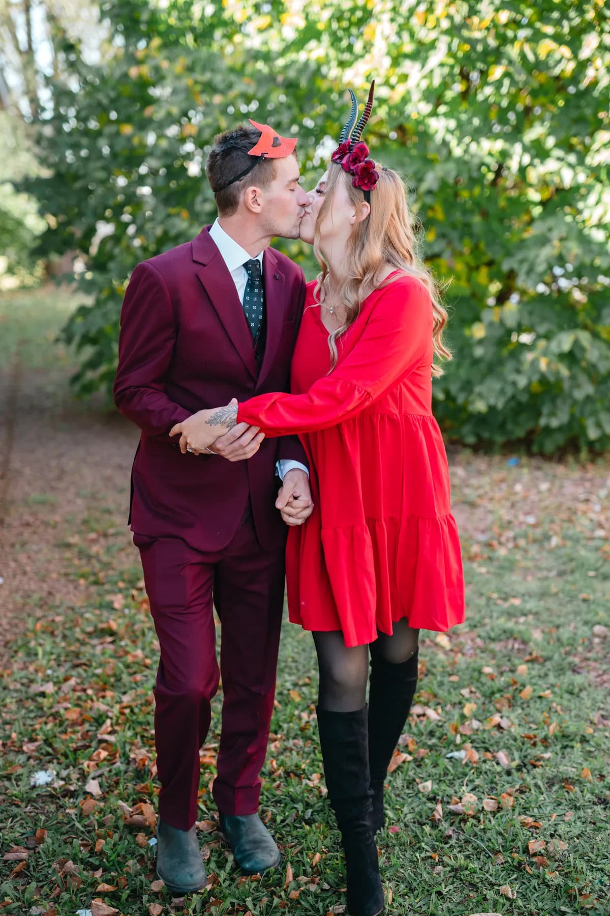 A couple posing outdoors near trees at Jenna and Jake’s Halloween party.