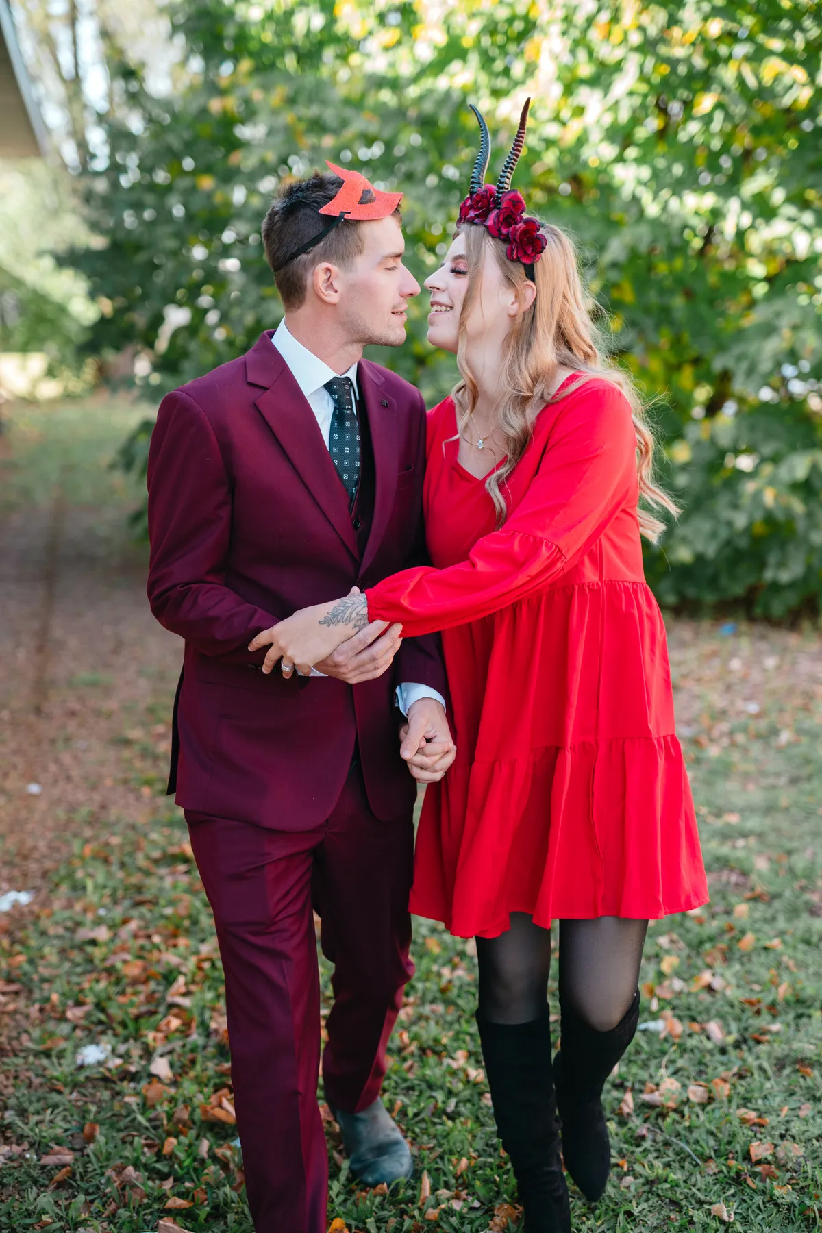 A couple posing outdoors near trees at Jenna and Jake’s Halloween party.