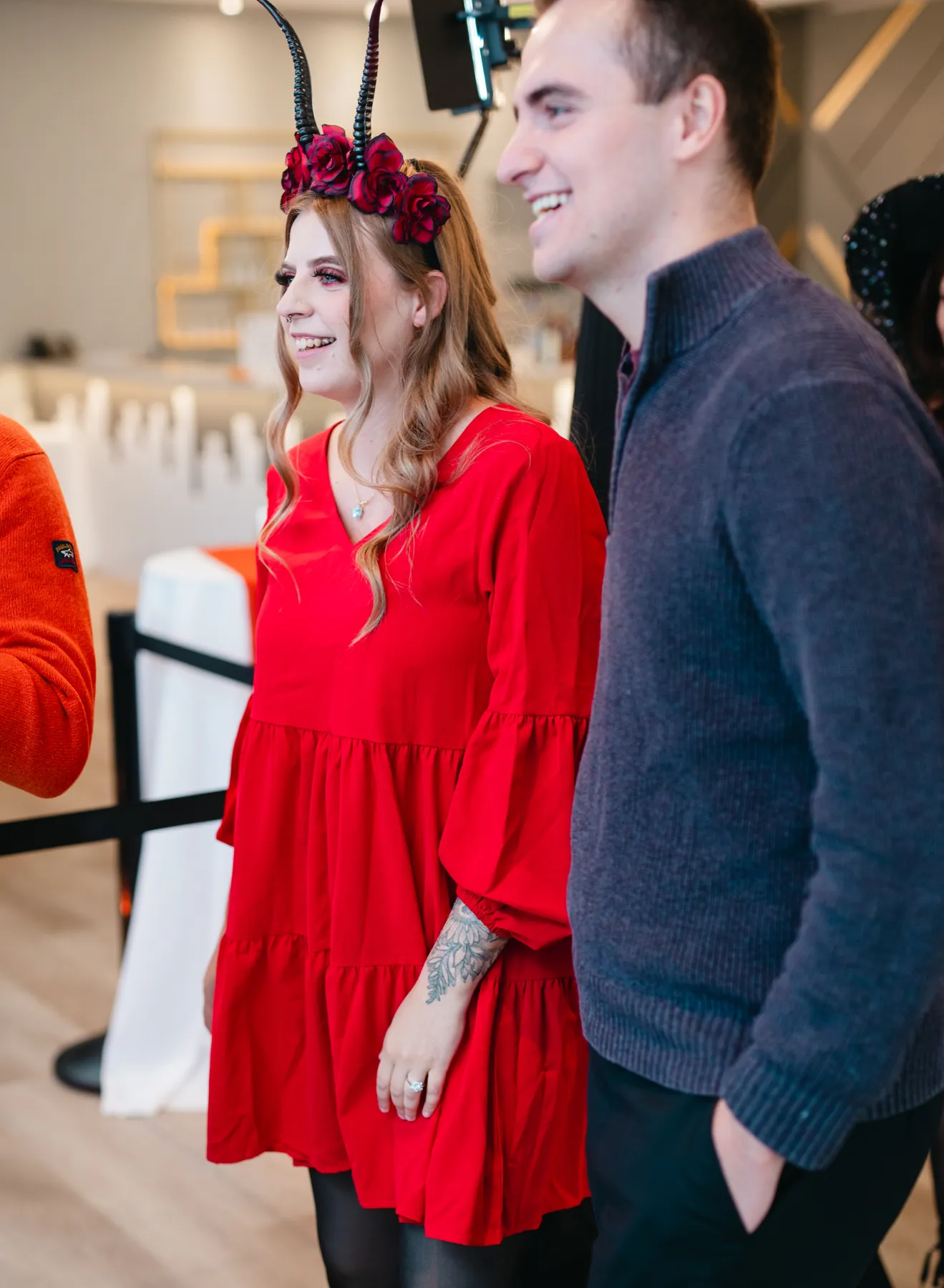 Guests posing and greeting indoors at Jenna and Jake’s Halloween party.