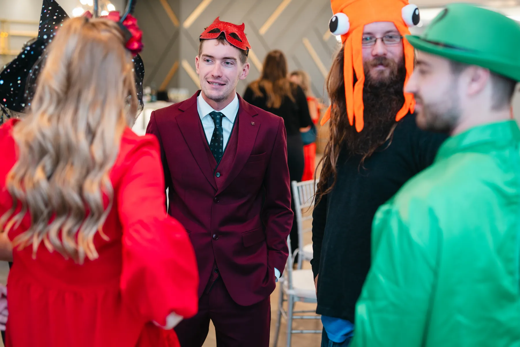 Guests posing and greeting indoors at Jenna and Jake’s Halloween party.