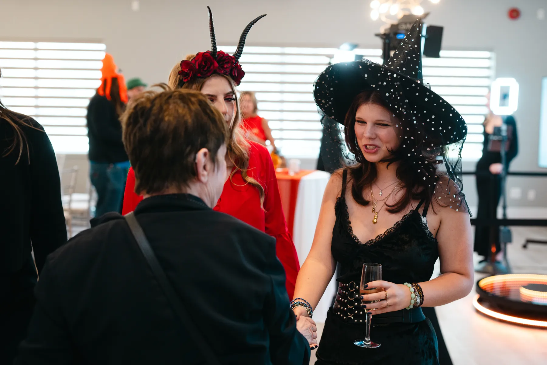 Costumed guests mingling indoors at Jenna and Jake’s Halloween party.