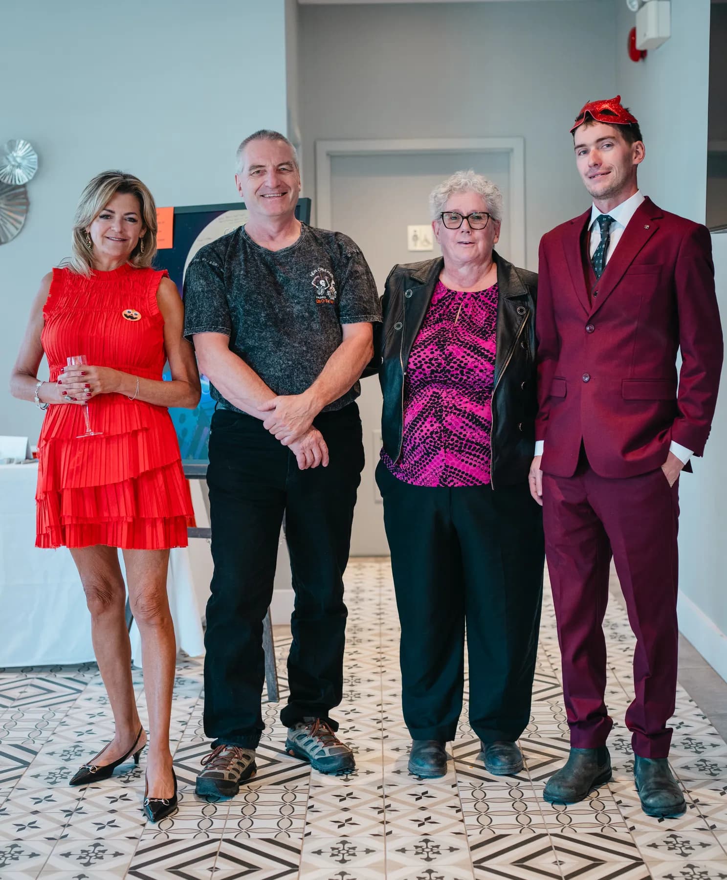 Small groups of guests posing indoors at Jenna and Jake’s Halloween party.