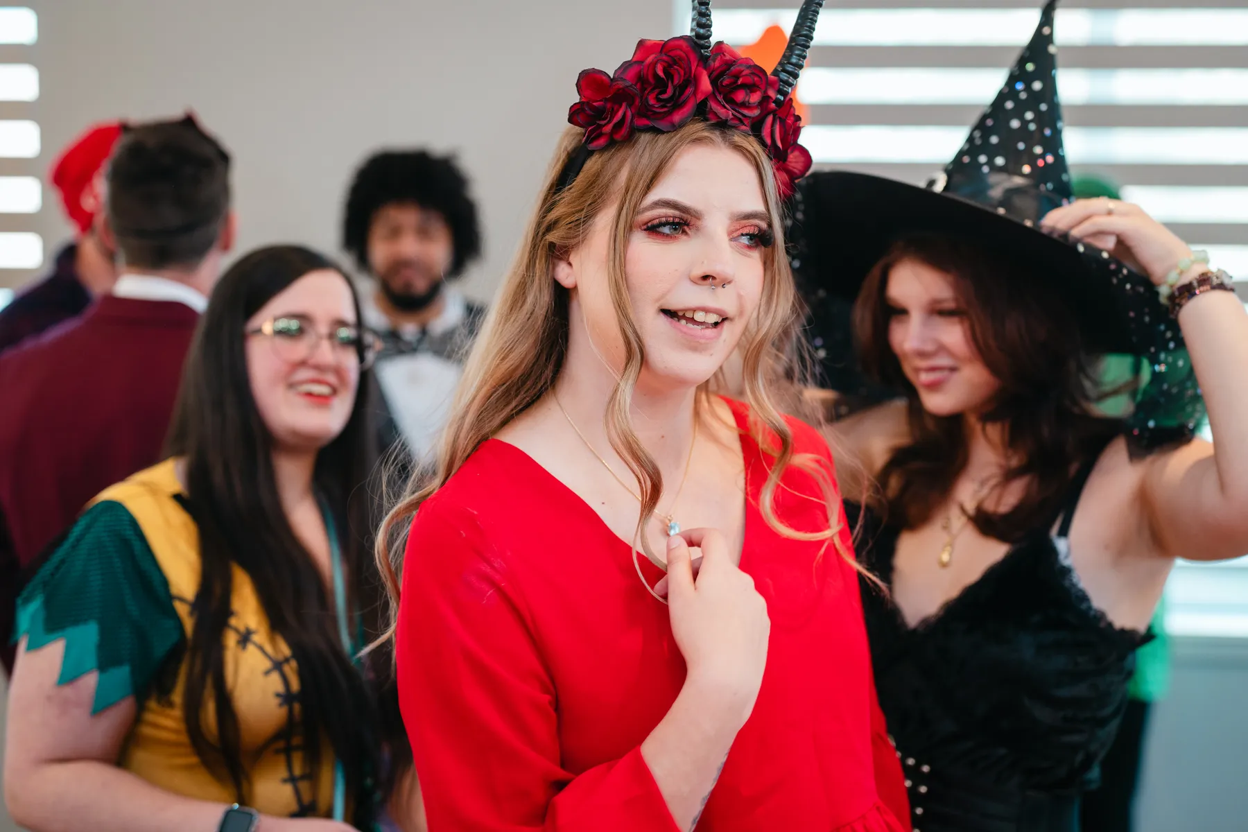 Costumed guests socializing around reception tables at Jenna and Jake’s Halloween party.