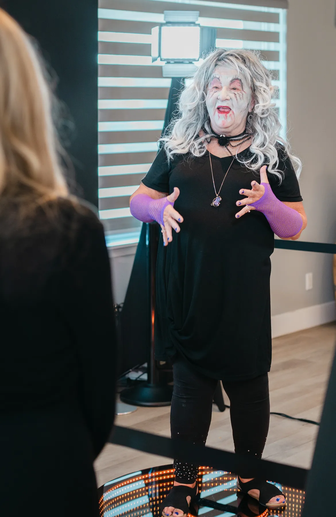 Costumed guests mingling and posing indoors at Jenna and Jake’s Halloween party.