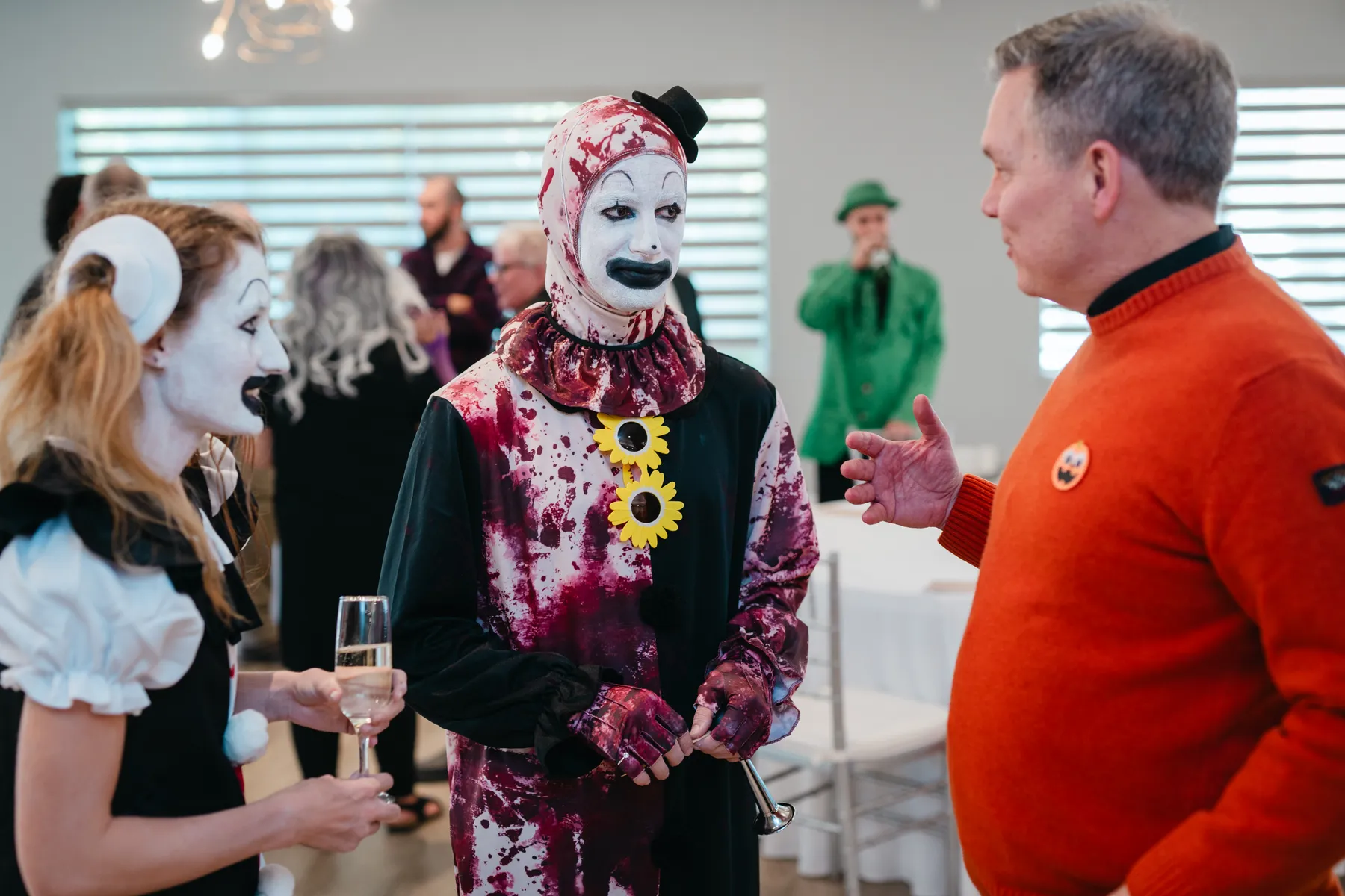 Guests in Halloween costumes talking together at Jenna and Jake’s Halloween party.