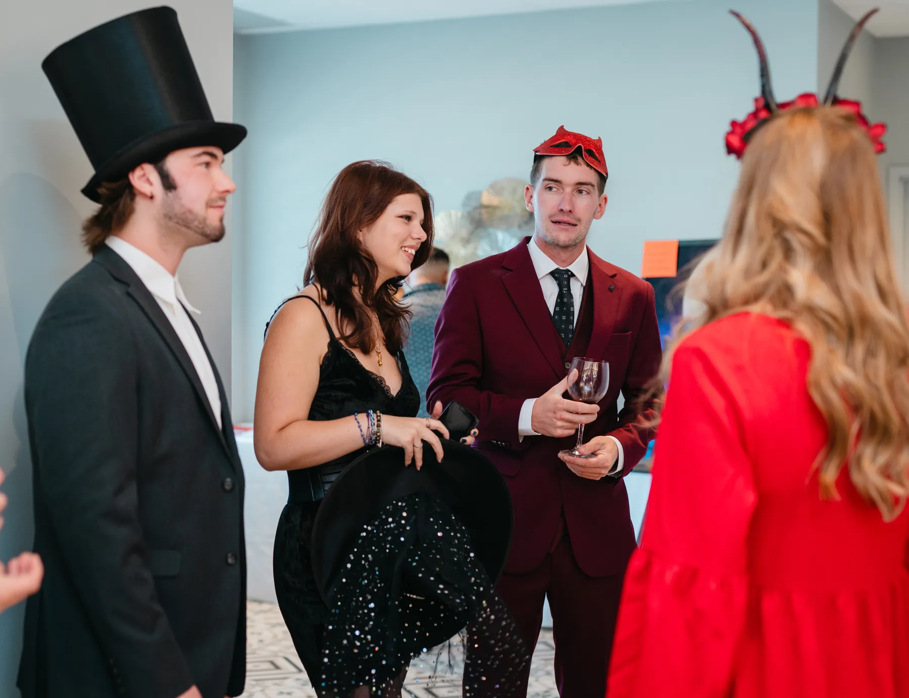 Costumed guests chatting and posing at Jenna and Jake’s Halloween party.