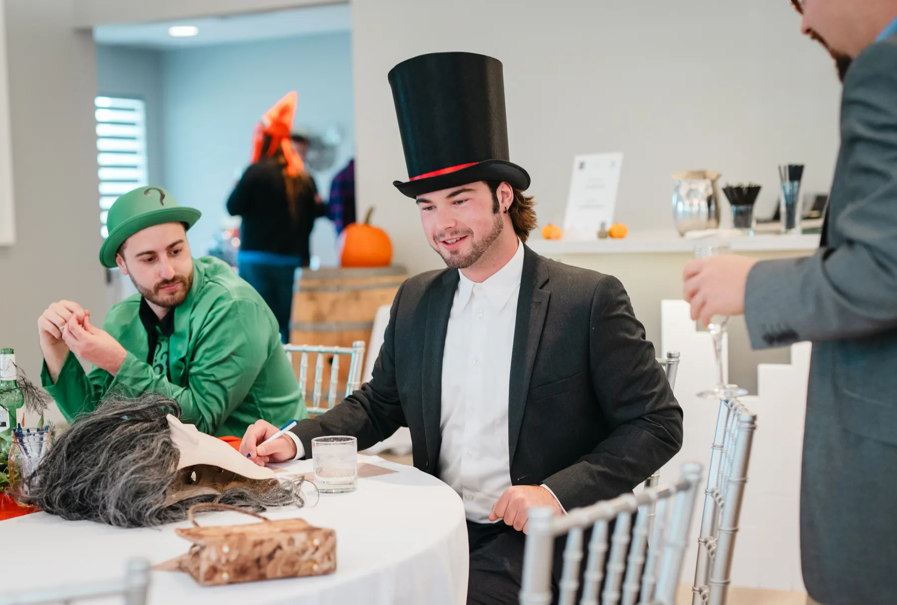 Guests chatting at party tables at Jenna and Jake’s Halloween party.