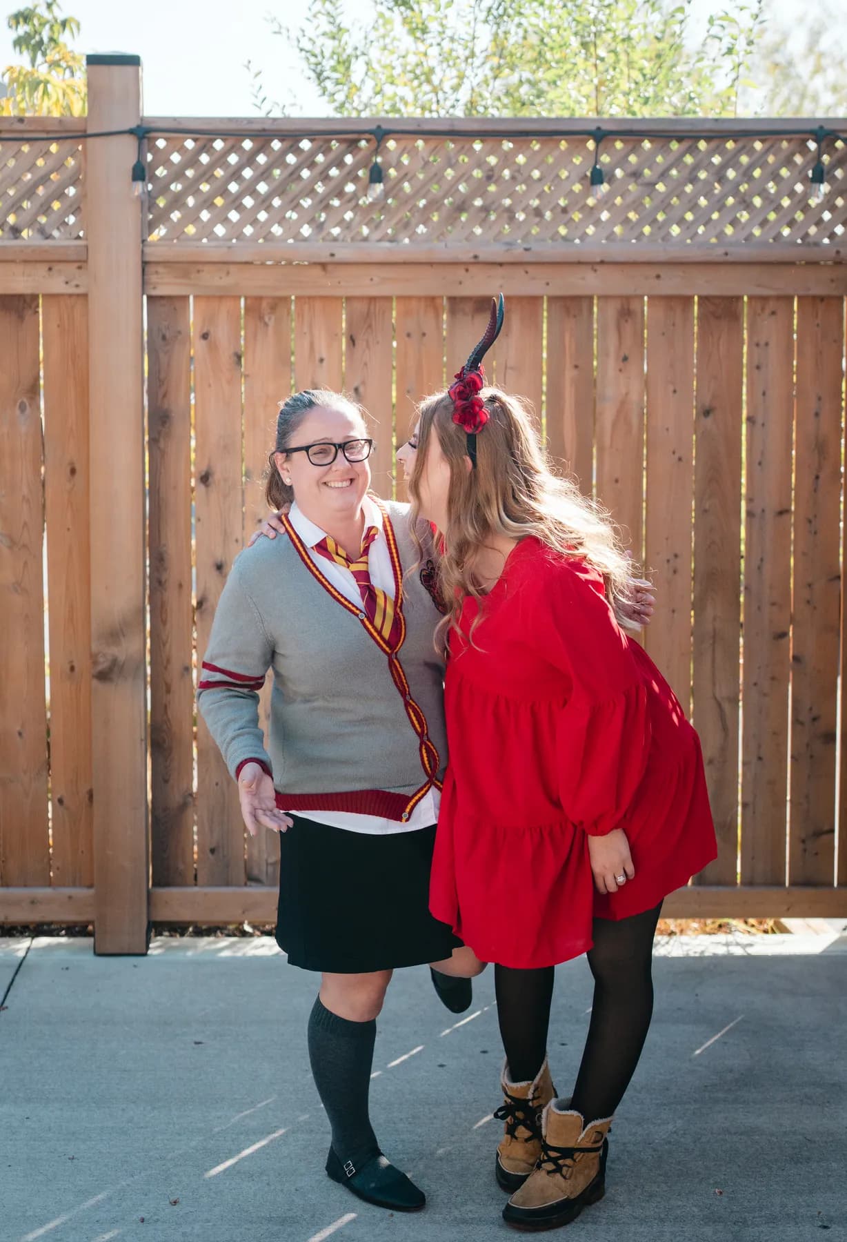 Two women celebrating together in an outdoor courtyard at Jenna and Jake’s Halloween party.