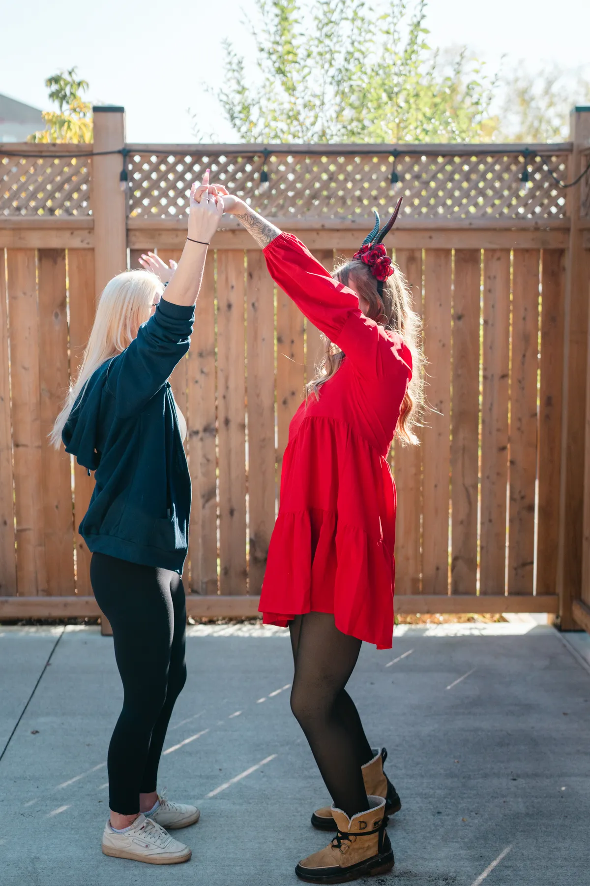 Two women celebrating together in an outdoor courtyard at Jenna and Jake’s Halloween party.