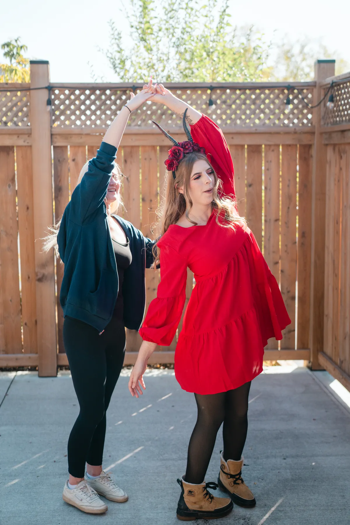 Two women celebrating together in an outdoor courtyard at Jenna and Jake’s Halloween party.