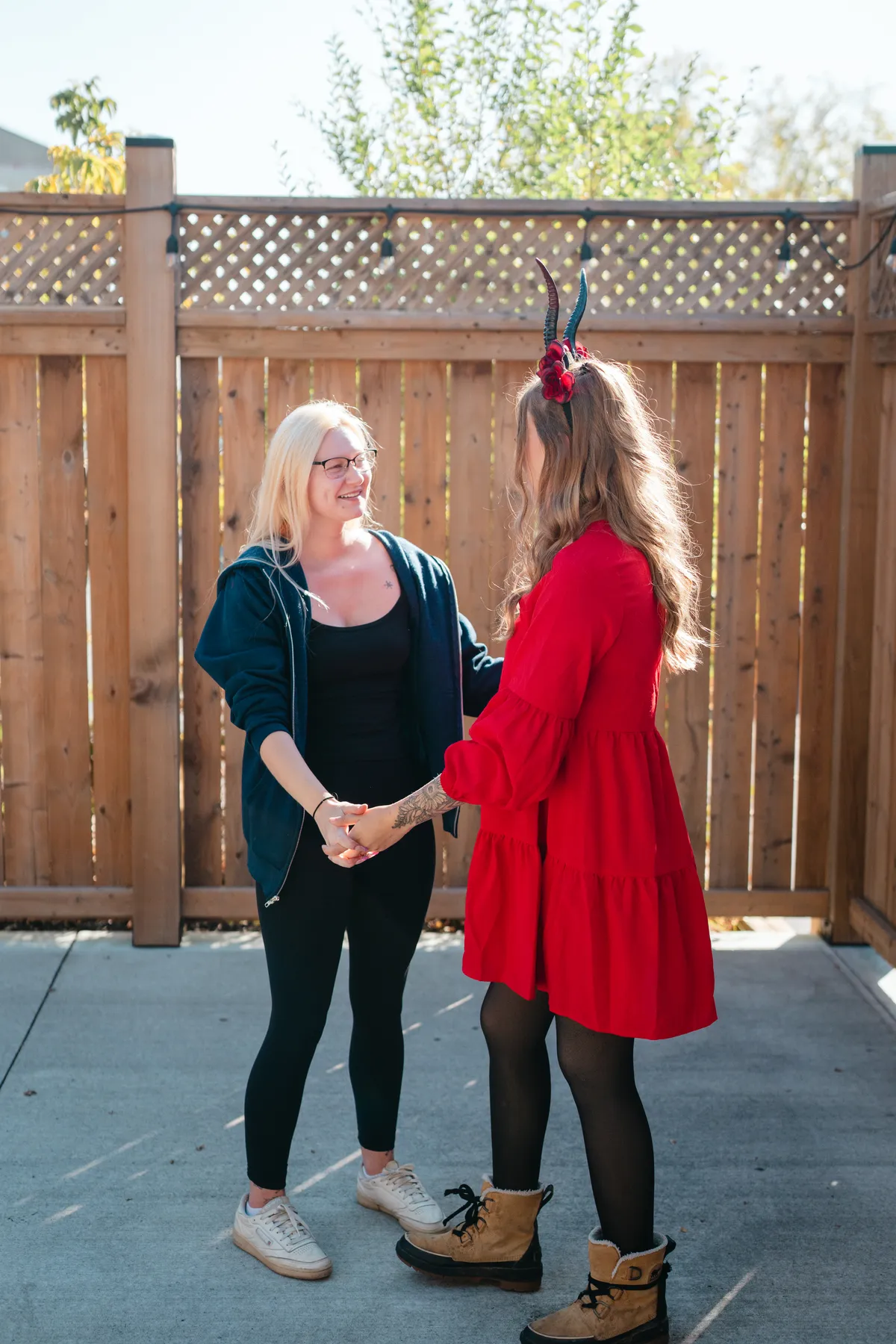 Two women celebrating together in an outdoor courtyard at Jenna and Jake’s Halloween party.