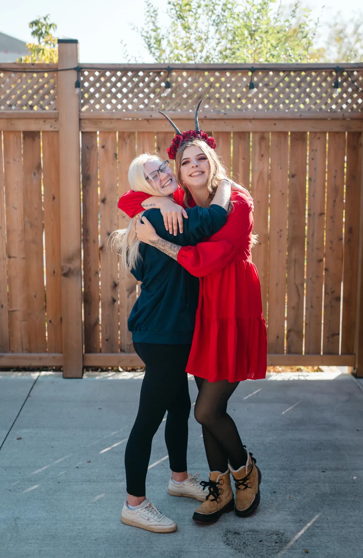 Two women celebrating together in an outdoor courtyard at Jenna and Jake’s Halloween party.