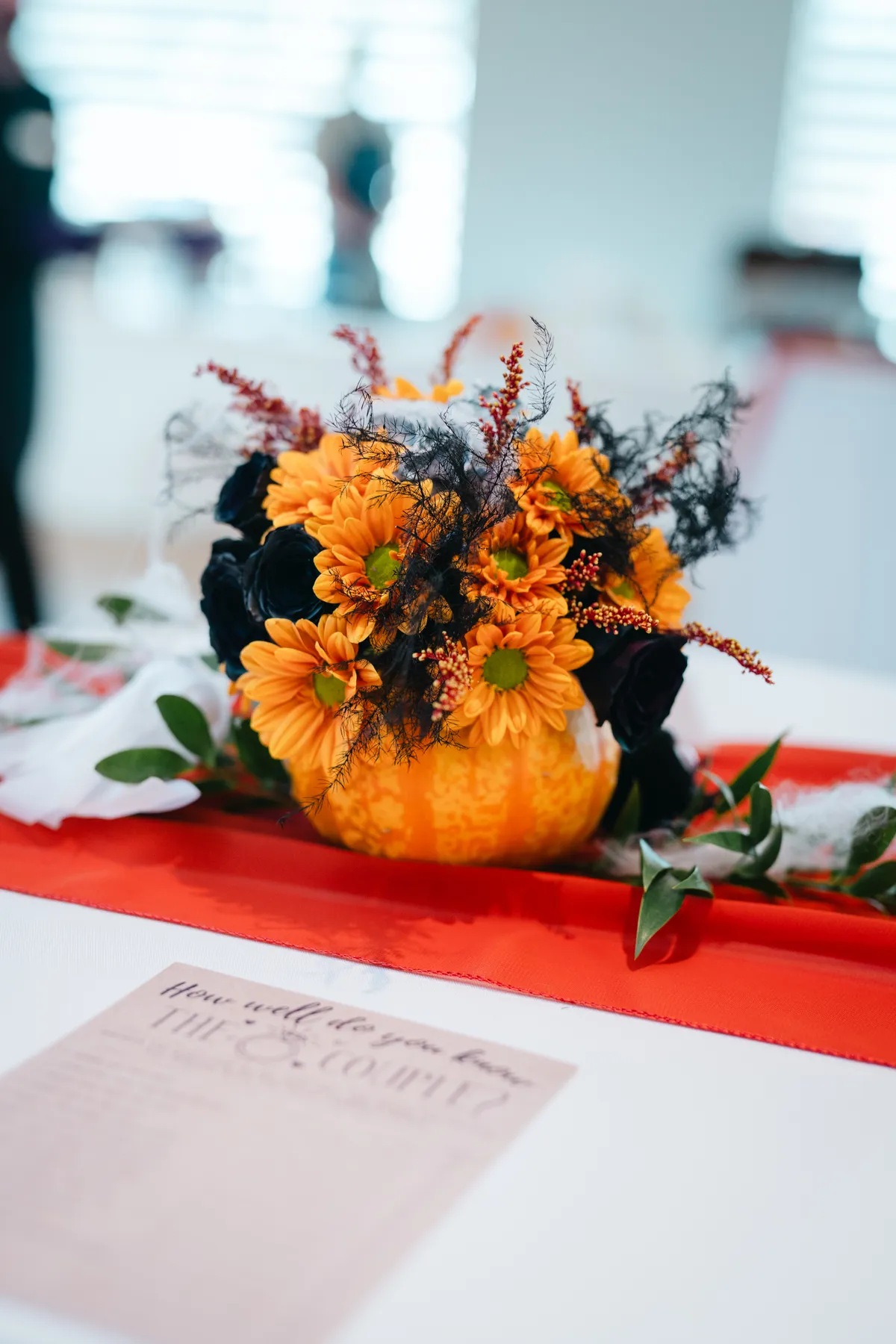 Guests mingling indoors with Halloween table decorations at Jenna and Jake’s Halloween party.