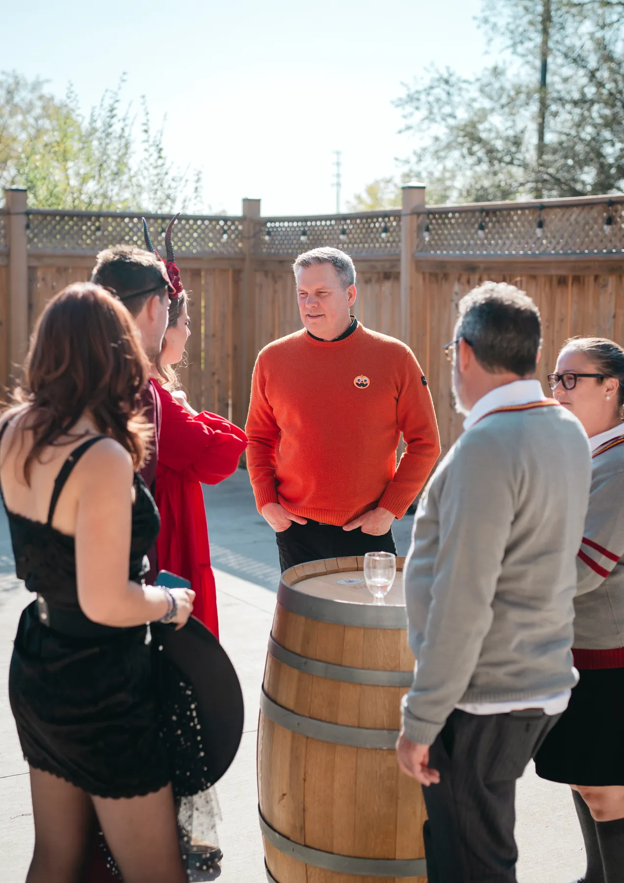 Costumed guests chatting in the outdoor courtyard at Jenna and Jake’s Halloween party.
