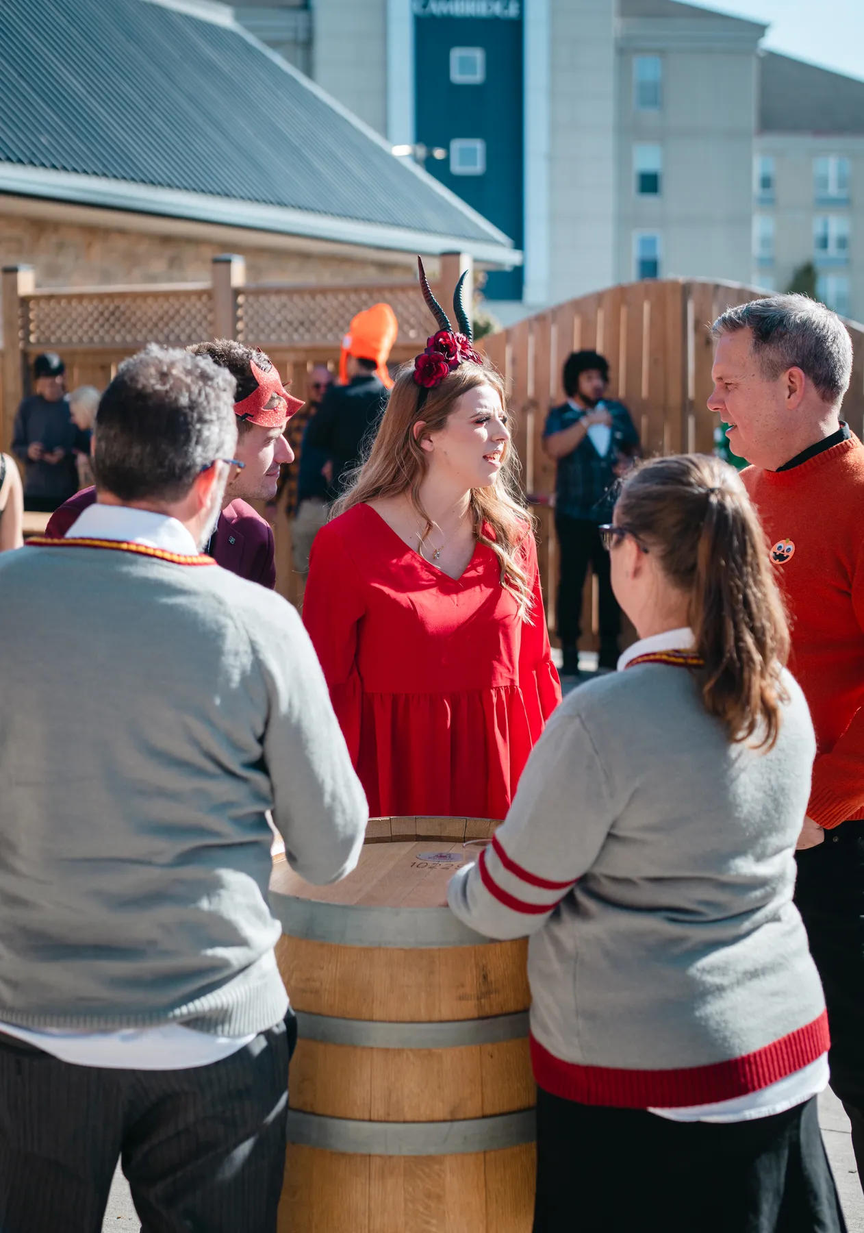 Costumed guests chatting in the outdoor courtyard at Jenna and Jake’s Halloween party.