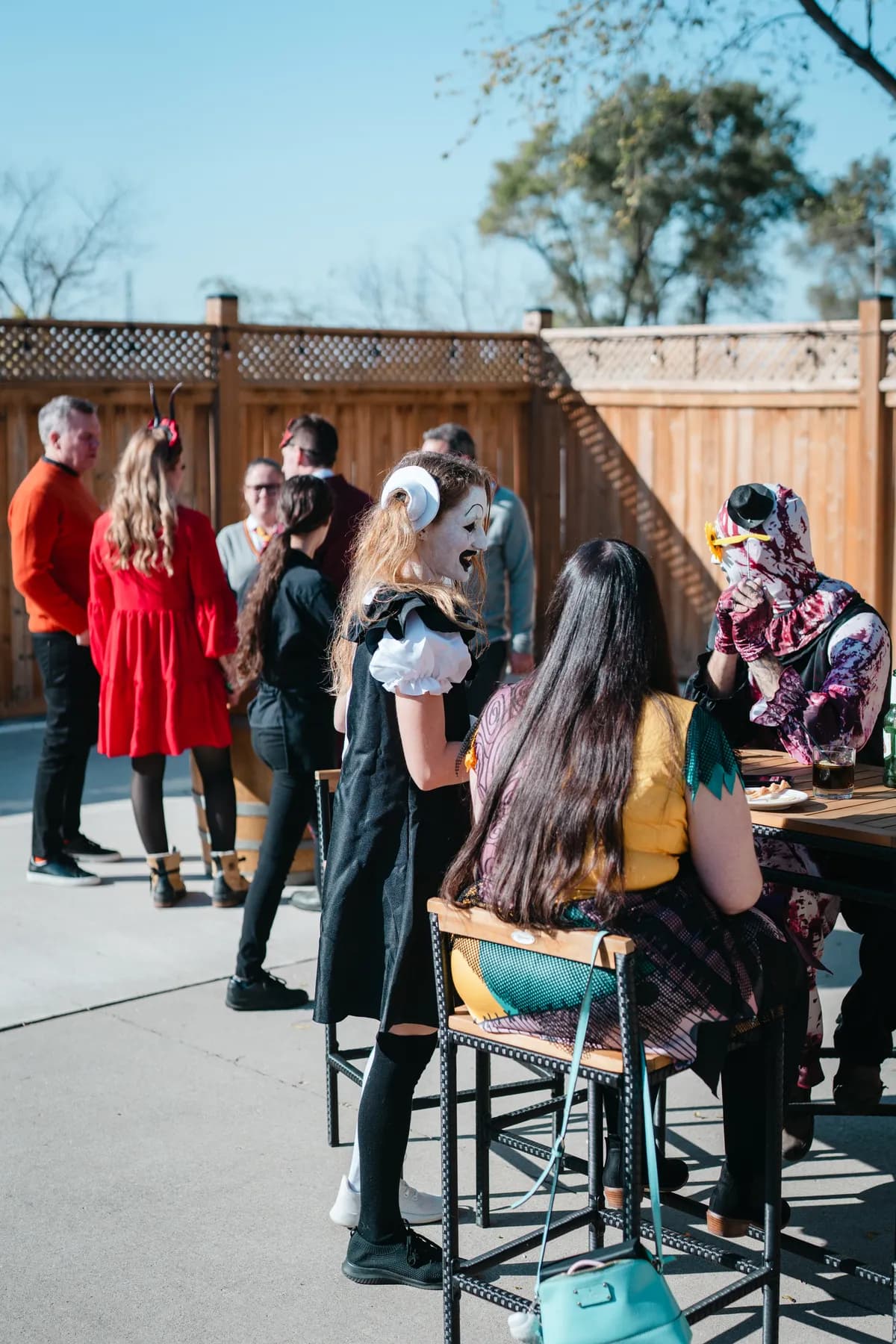 Costumed guests chatting in the outdoor courtyard at Jenna and Jake’s Halloween party.
