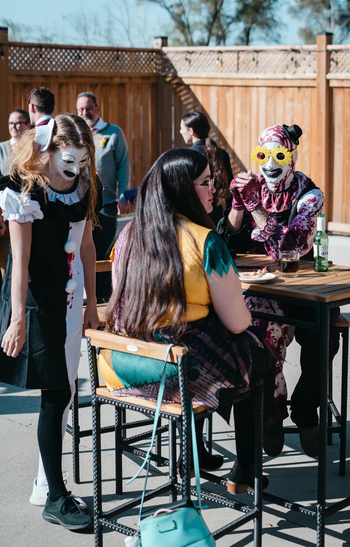 Costumed guests chatting in the outdoor courtyard at Jenna and Jake’s Halloween party.