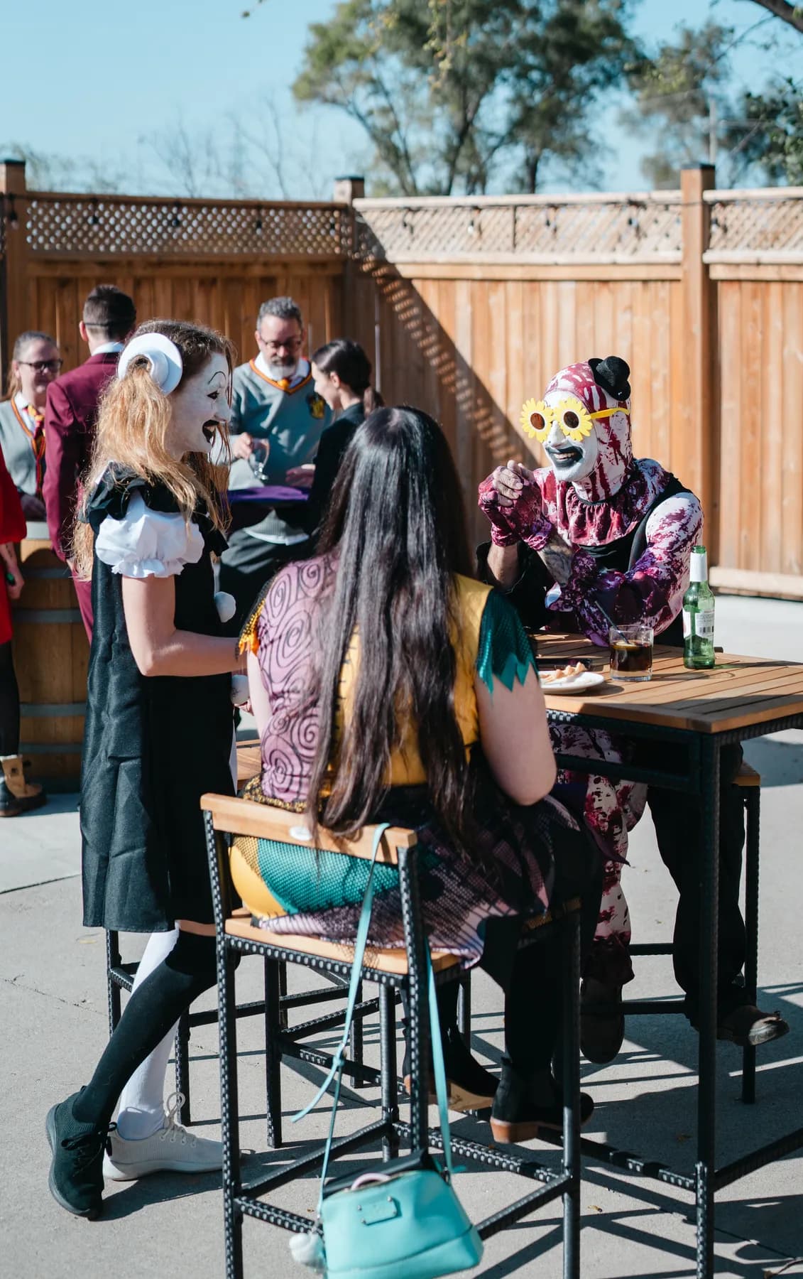 Costumed guests chatting in the outdoor courtyard at Jenna and Jake’s Halloween party.