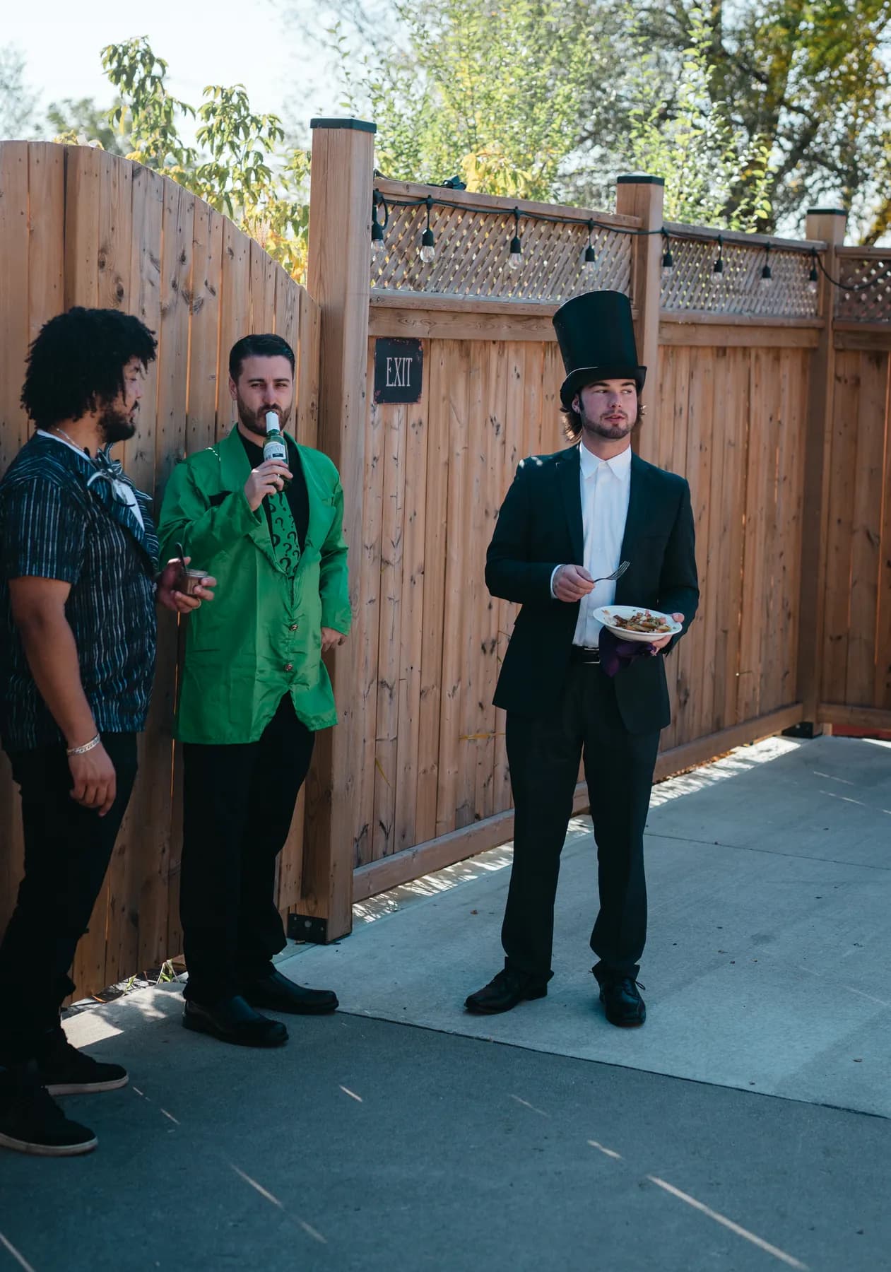 Costumed guests chatting in the outdoor courtyard at Jenna and Jake’s Halloween party.