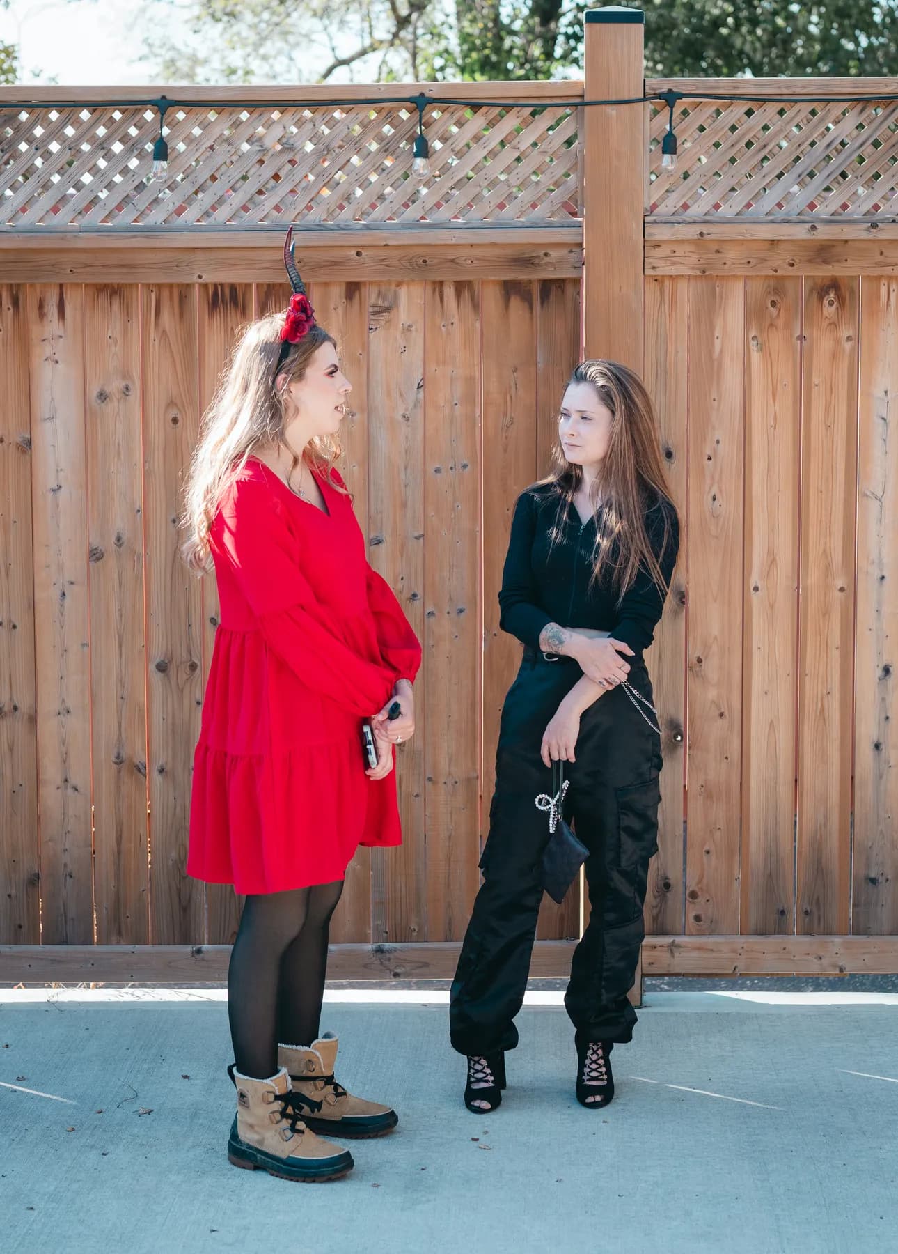Two women dancing and posing in the outdoor courtyard at Jenna and Jake’s Halloween party.