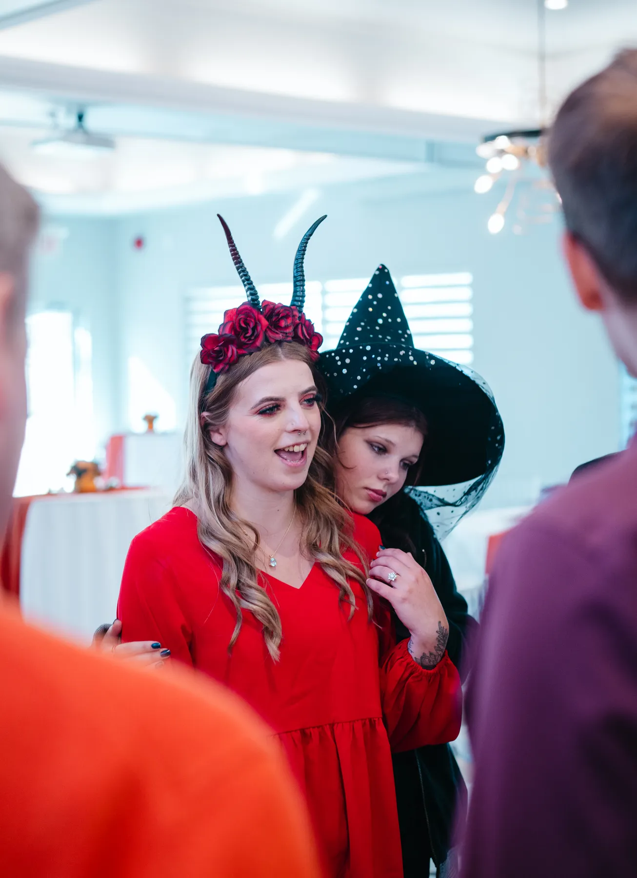 Guests chatting and posing around party tables at Jenna and Jake’s Halloween party.