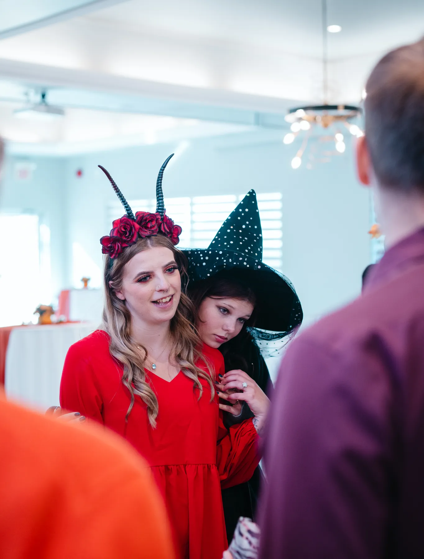 Guests chatting and posing around party tables at Jenna and Jake’s Halloween party.