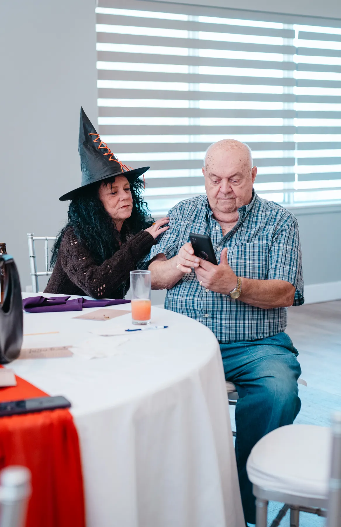 Guests in conversation at reception tables at Jenna and Jake’s Halloween party.