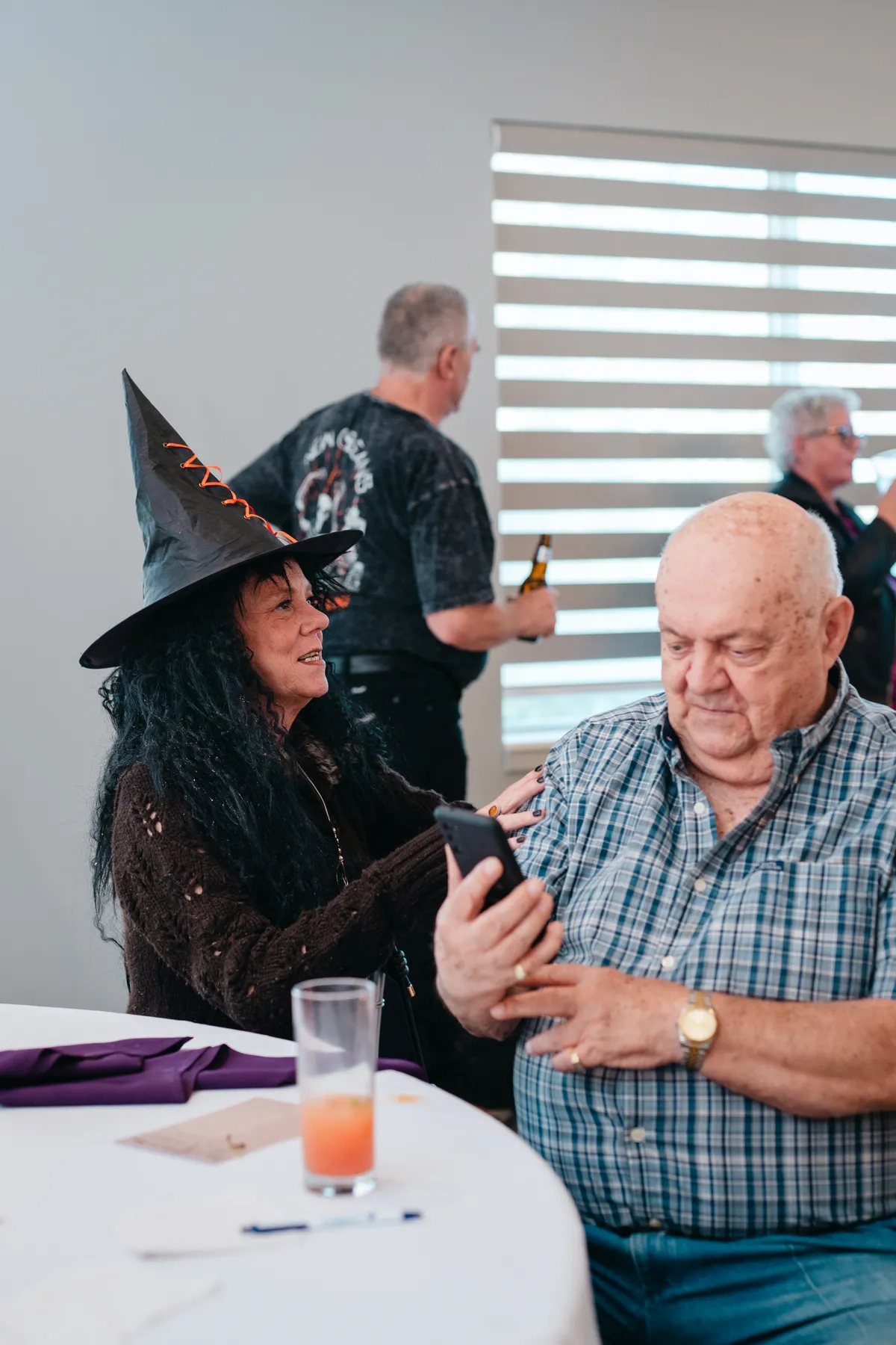 Guests in conversation at reception tables at Jenna and Jake’s Halloween party.