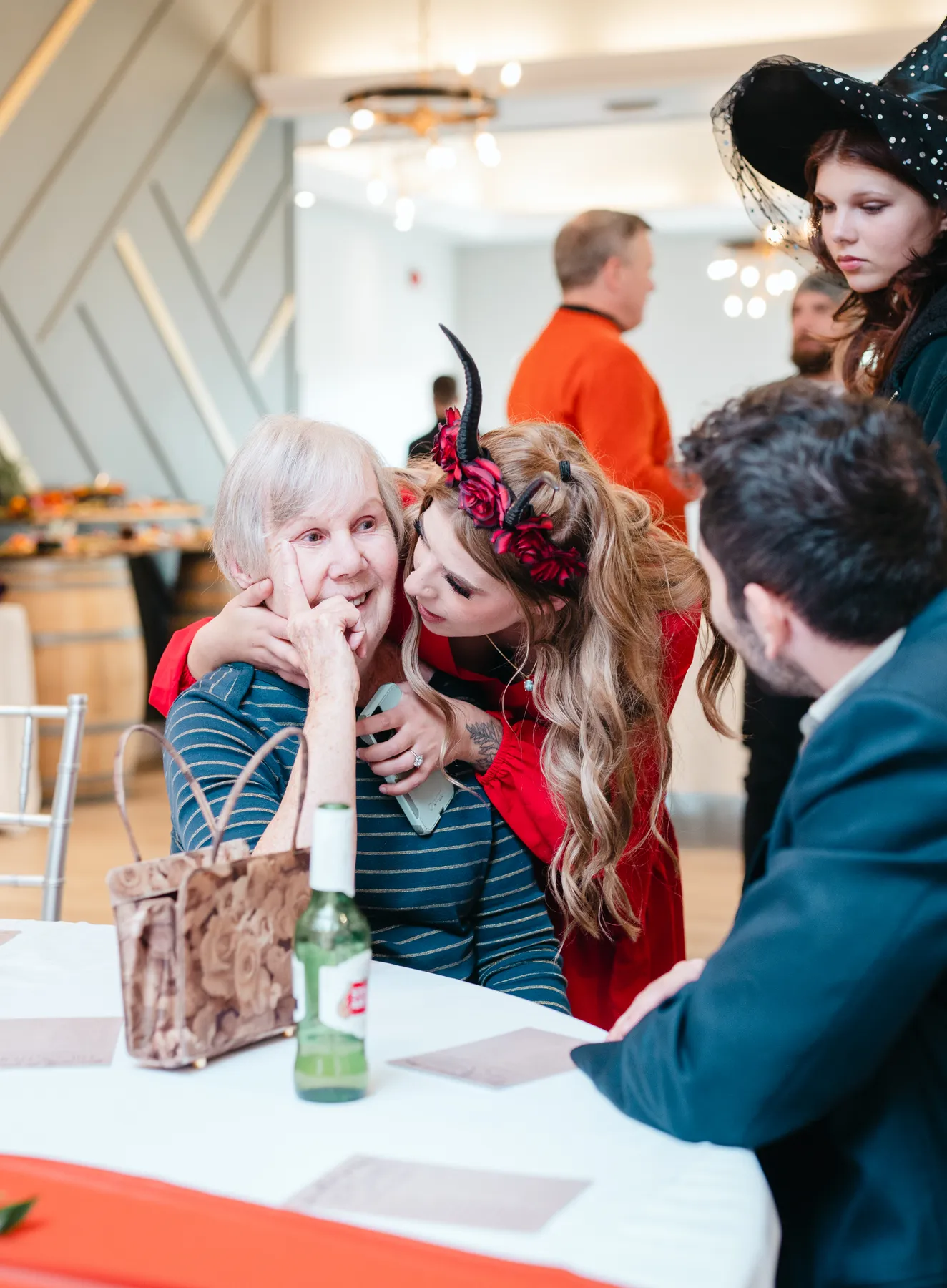 Guests in conversation at reception tables at Jenna and Jake’s Halloween party.
