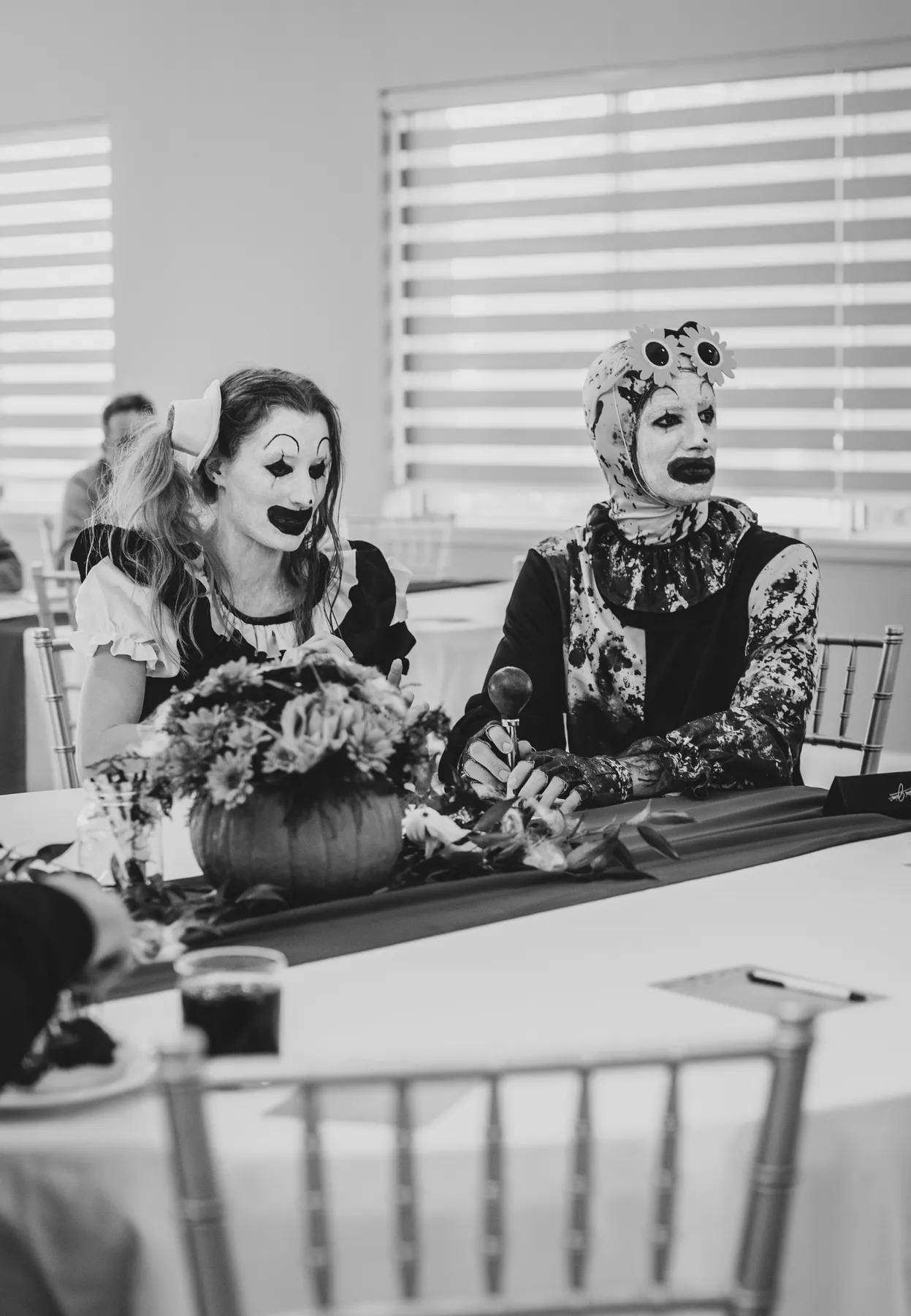 Costumed guests seated at a decorated table at Jenna and Jake’s Halloween party.