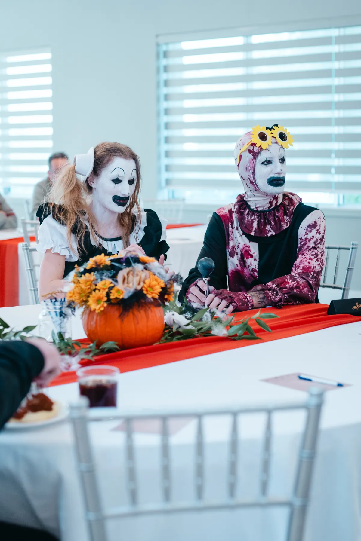Costumed guests seated at a decorated table at Jenna and Jake’s Halloween party.