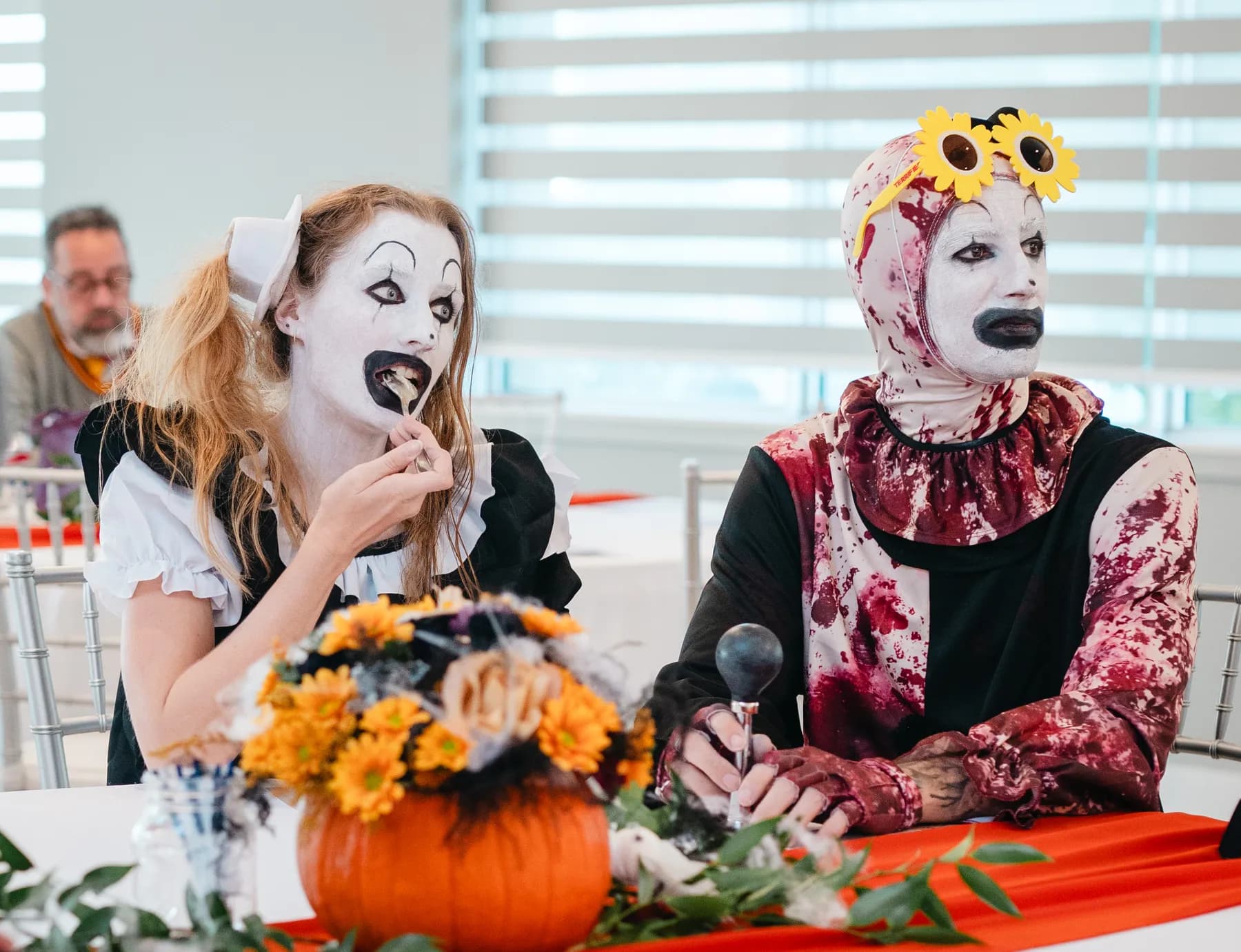 Costumed guests seated at a decorated table at Jenna and Jake’s Halloween party.