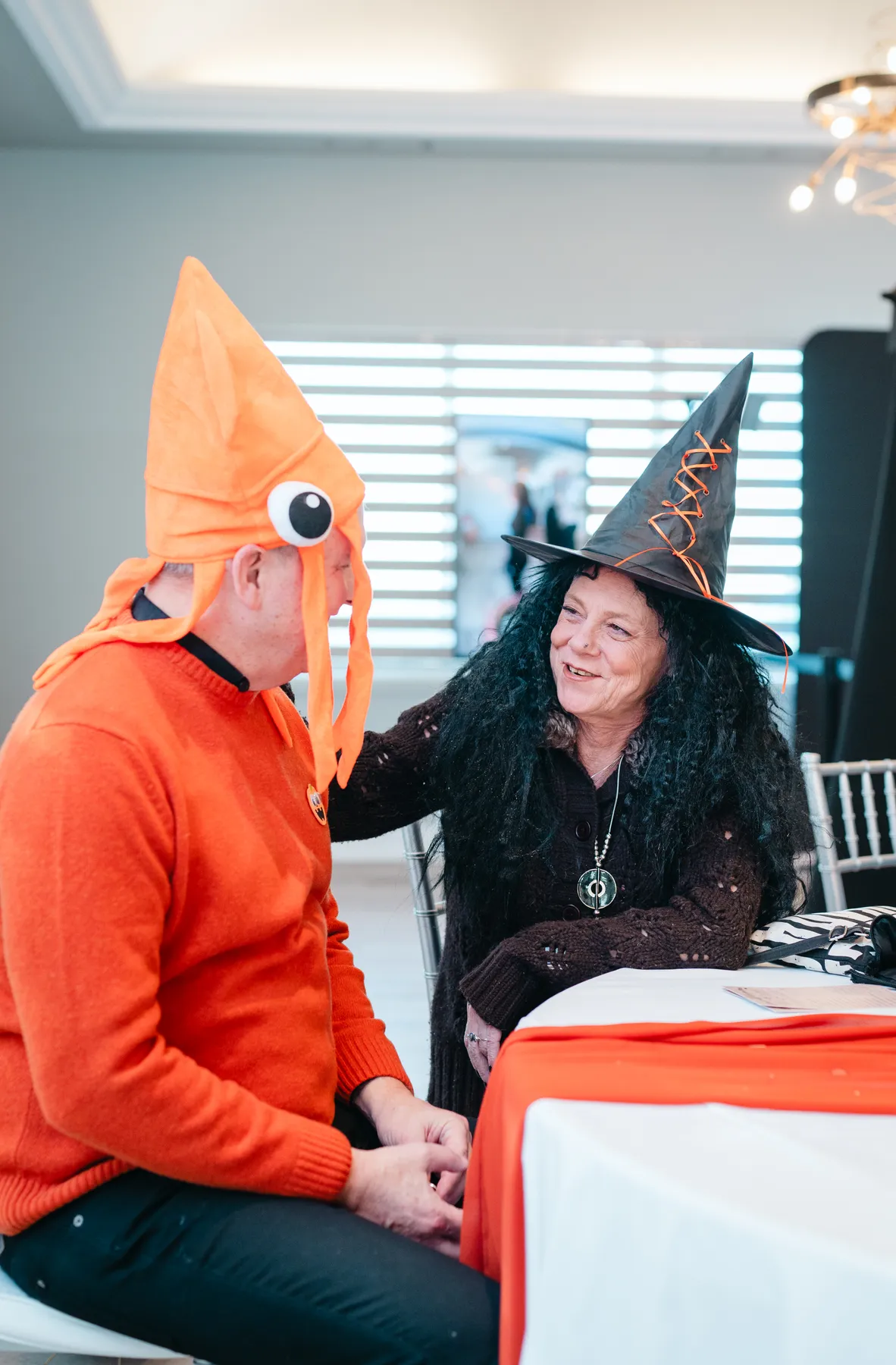 Guests chatting at party tables at Jenna and Jake’s Halloween party.