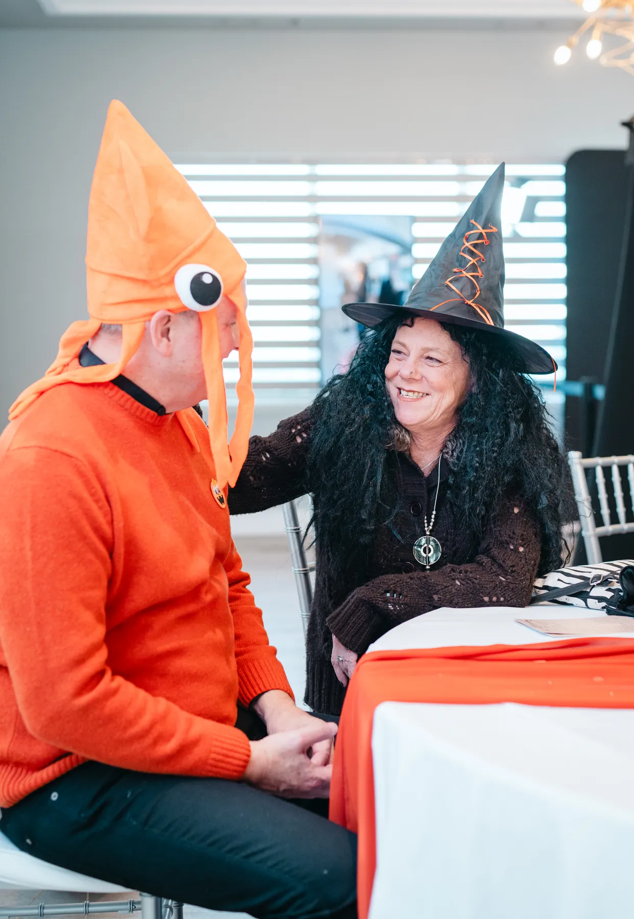 Guests chatting at party tables at Jenna and Jake’s Halloween party.