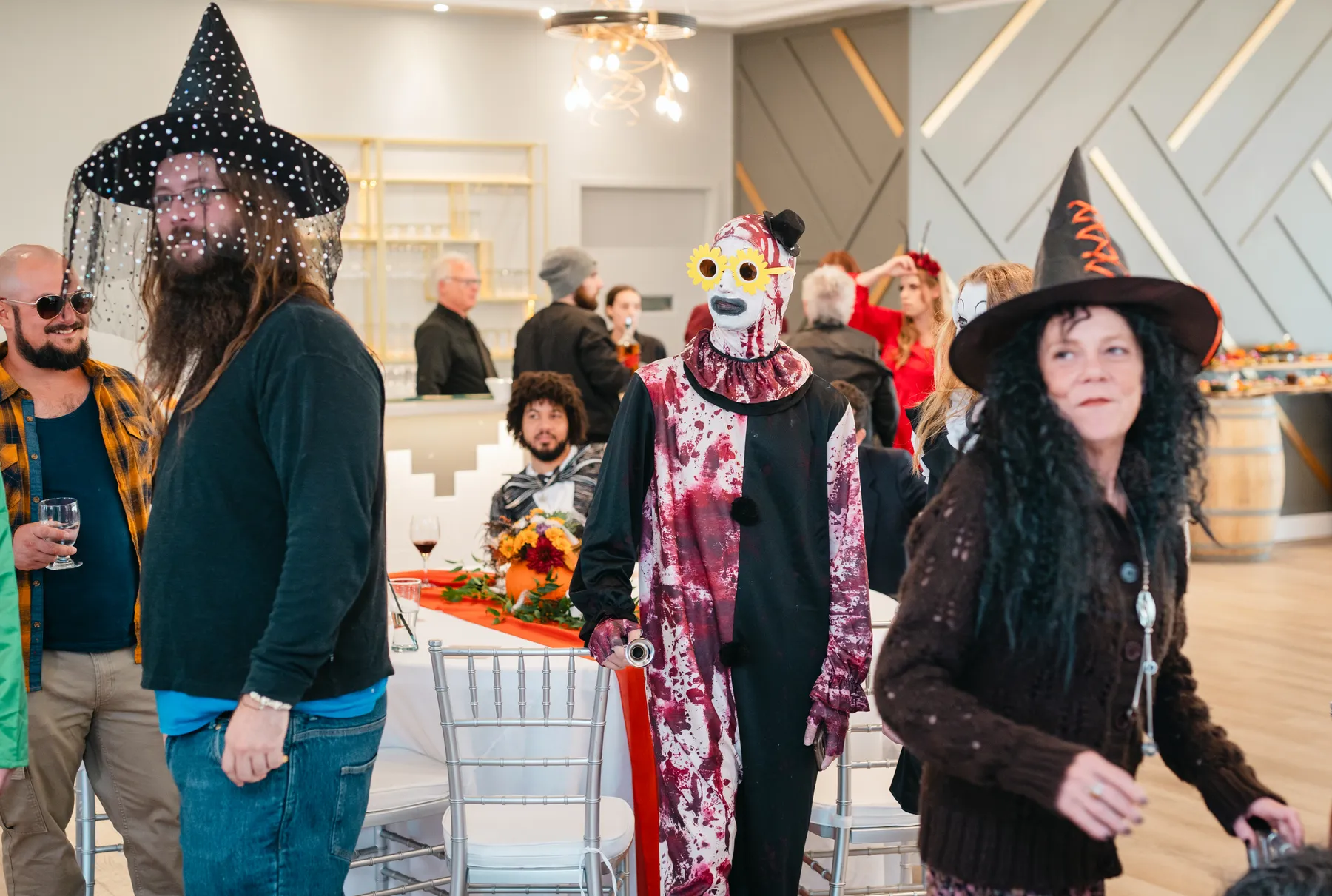 Costumed guests posing and mingling at Jenna and Jake’s Halloween party.