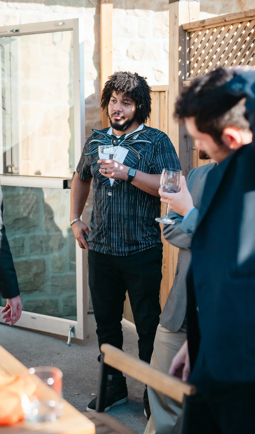 Guests walking and chatting in the outdoor courtyard at Jenna and Jake’s Halloween party.