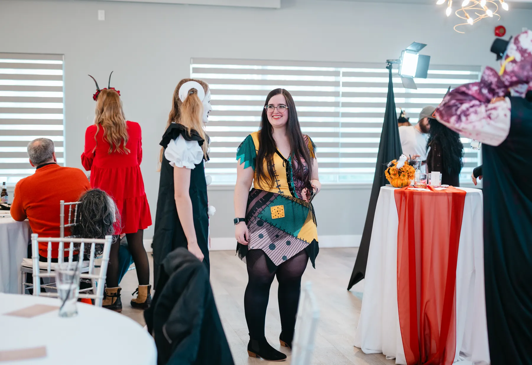 Guests posing and talking near Halloween decorations at Jenna and Jake’s Halloween party.