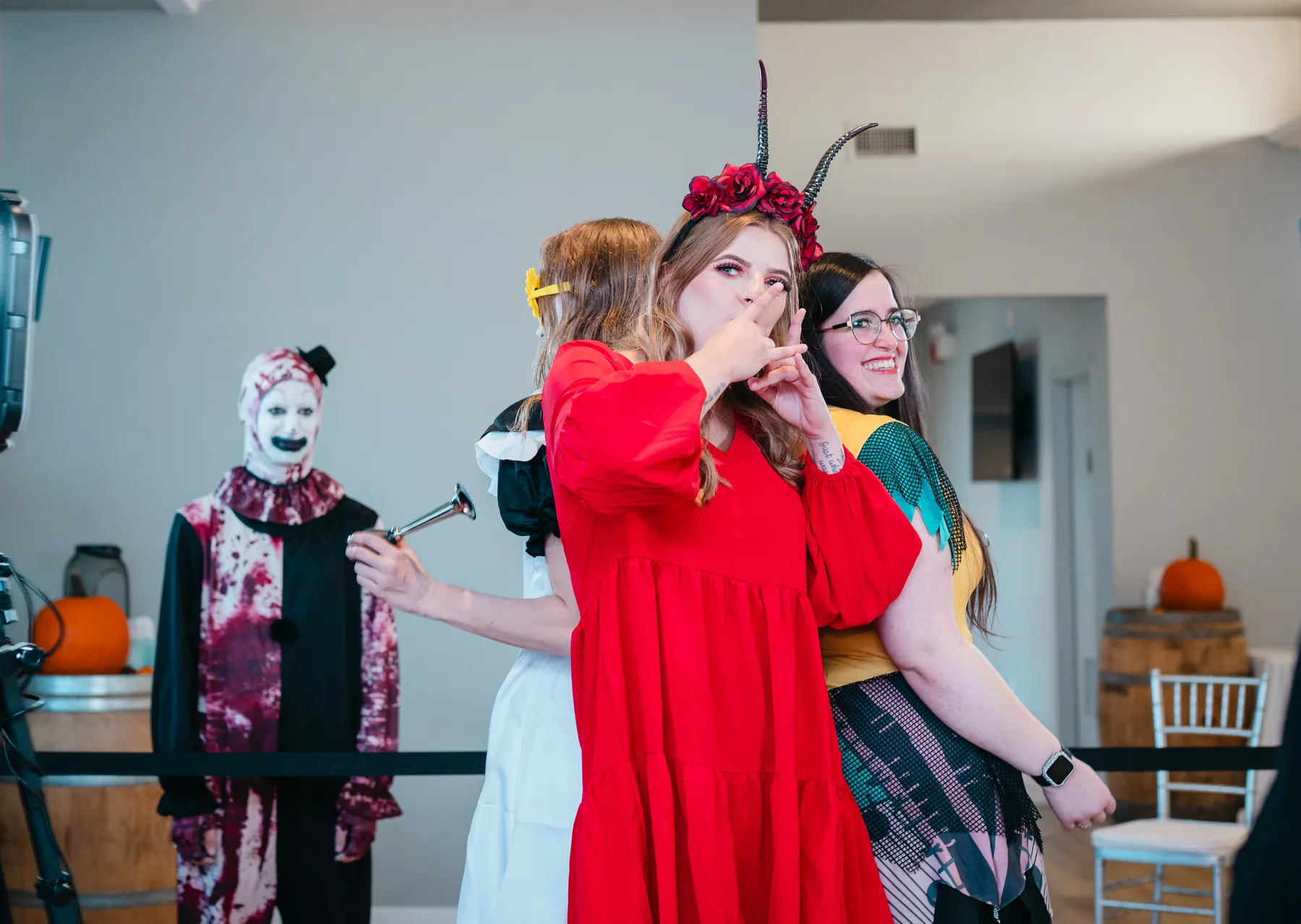 Guests posing and talking near Halloween decorations at Jenna and Jake’s Halloween party.