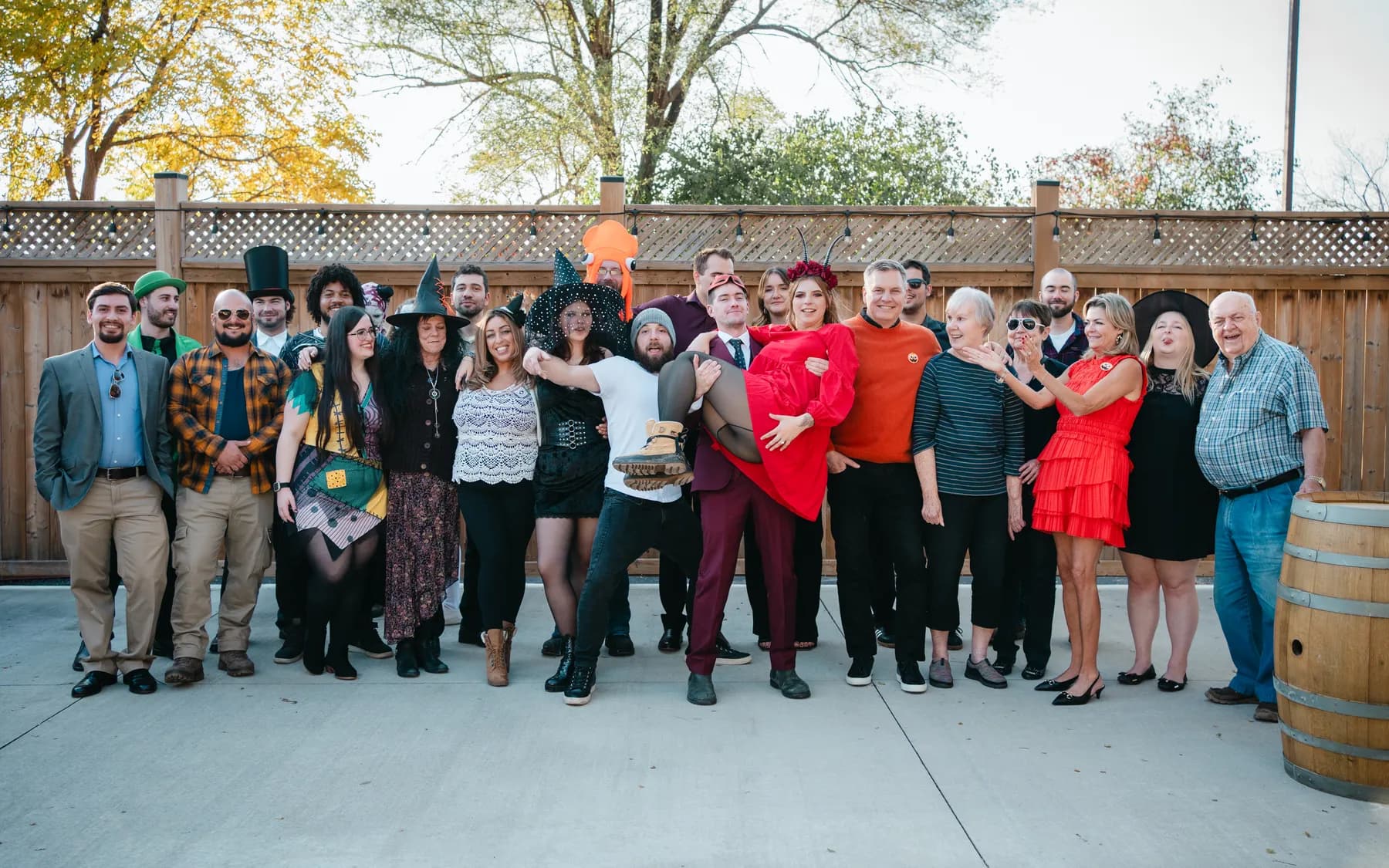A large group of Halloween party guests posing outdoors at Jenna and Jake’s Halloween party.