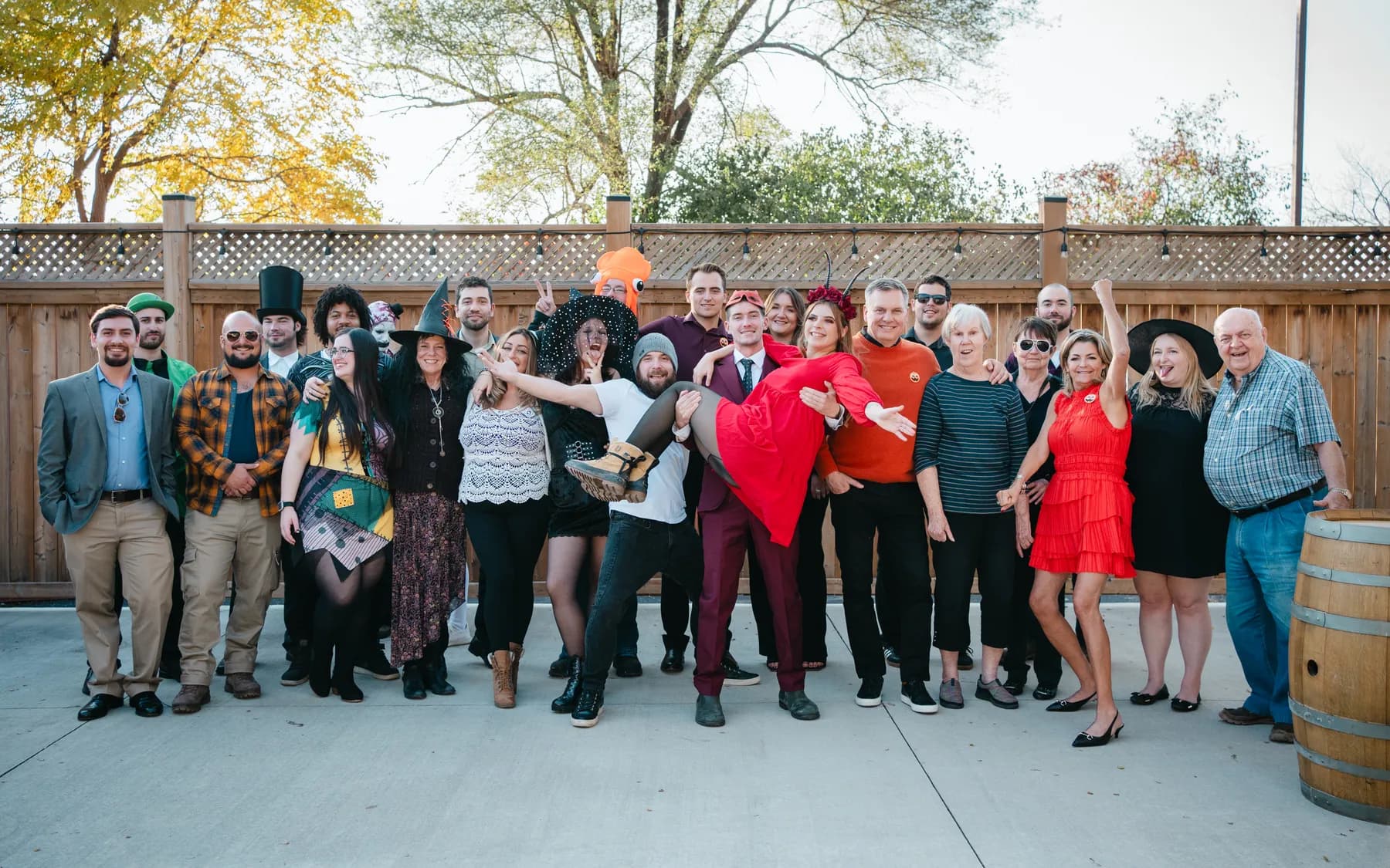A large group of Halloween party guests posing outdoors at Jenna and Jake’s Halloween party.