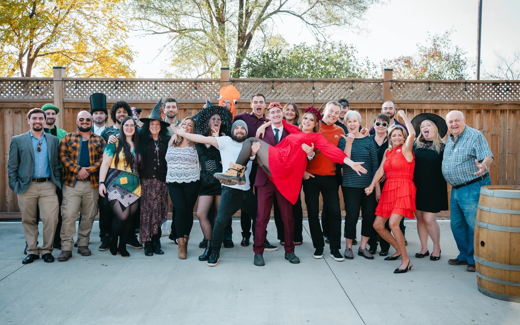 A large group of Halloween party guests posing outdoors at Jenna and Jake’s Halloween party.