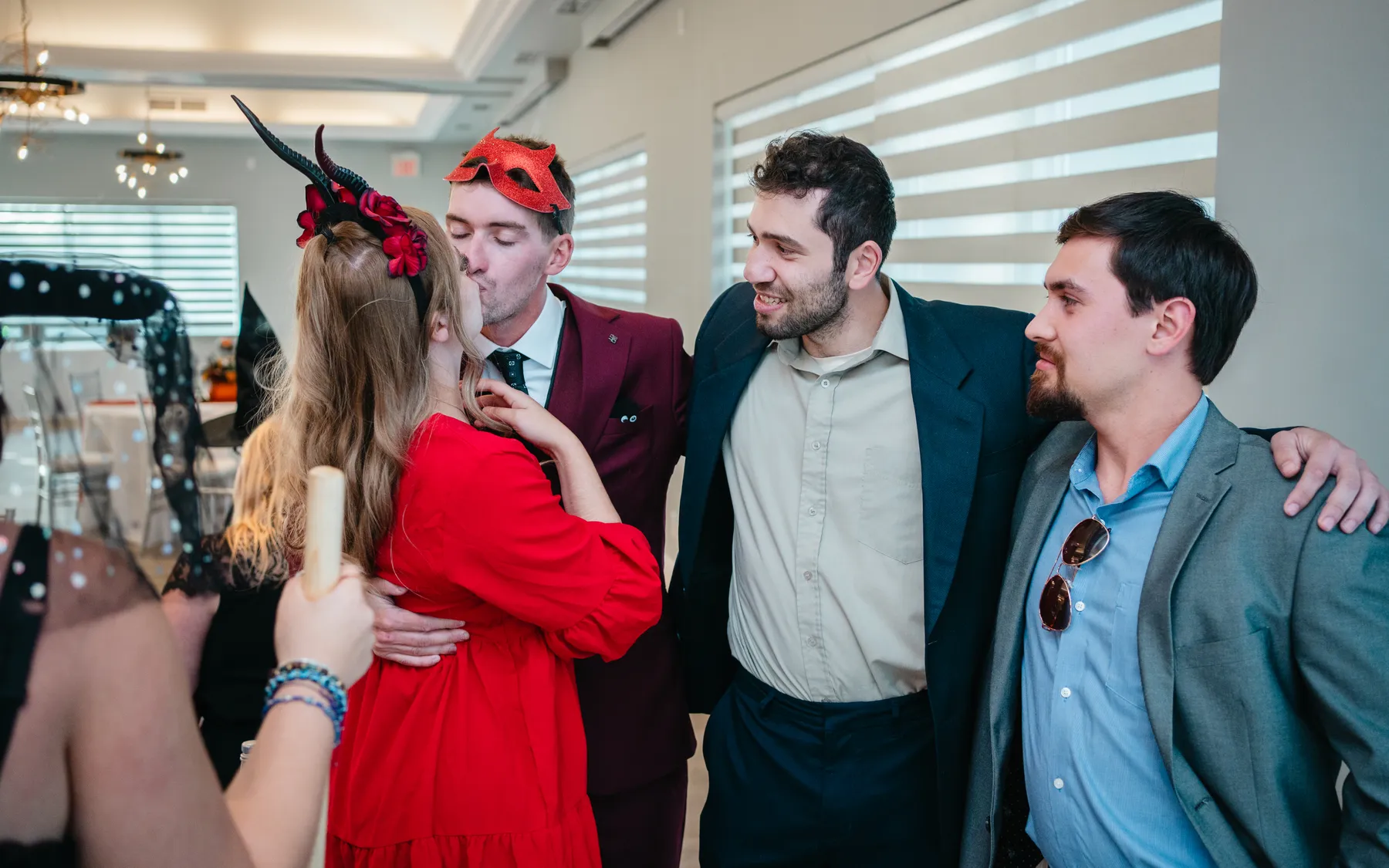A small group of guests posing indoors at Jenna and Jake’s Halloween party.