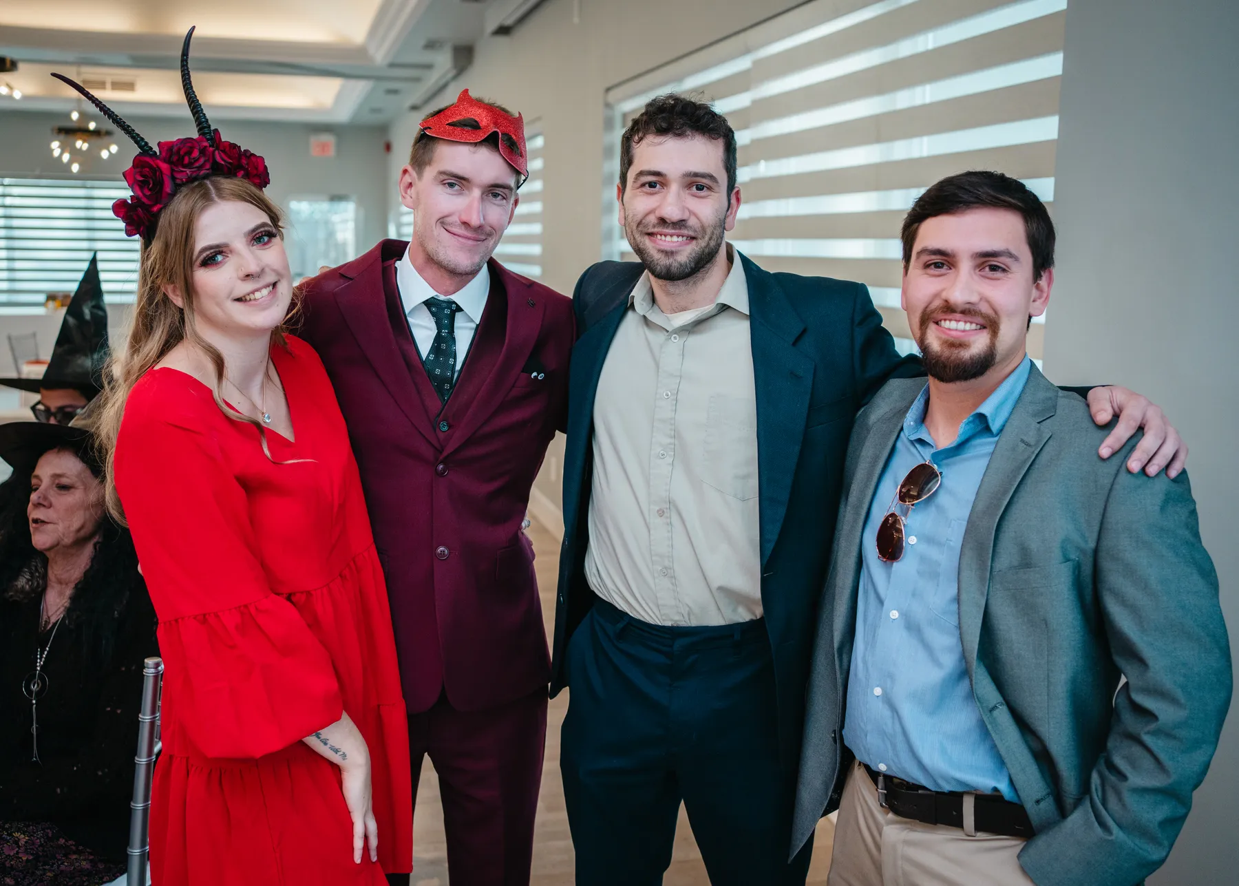 A small group of guests posing indoors at Jenna and Jake’s Halloween party.