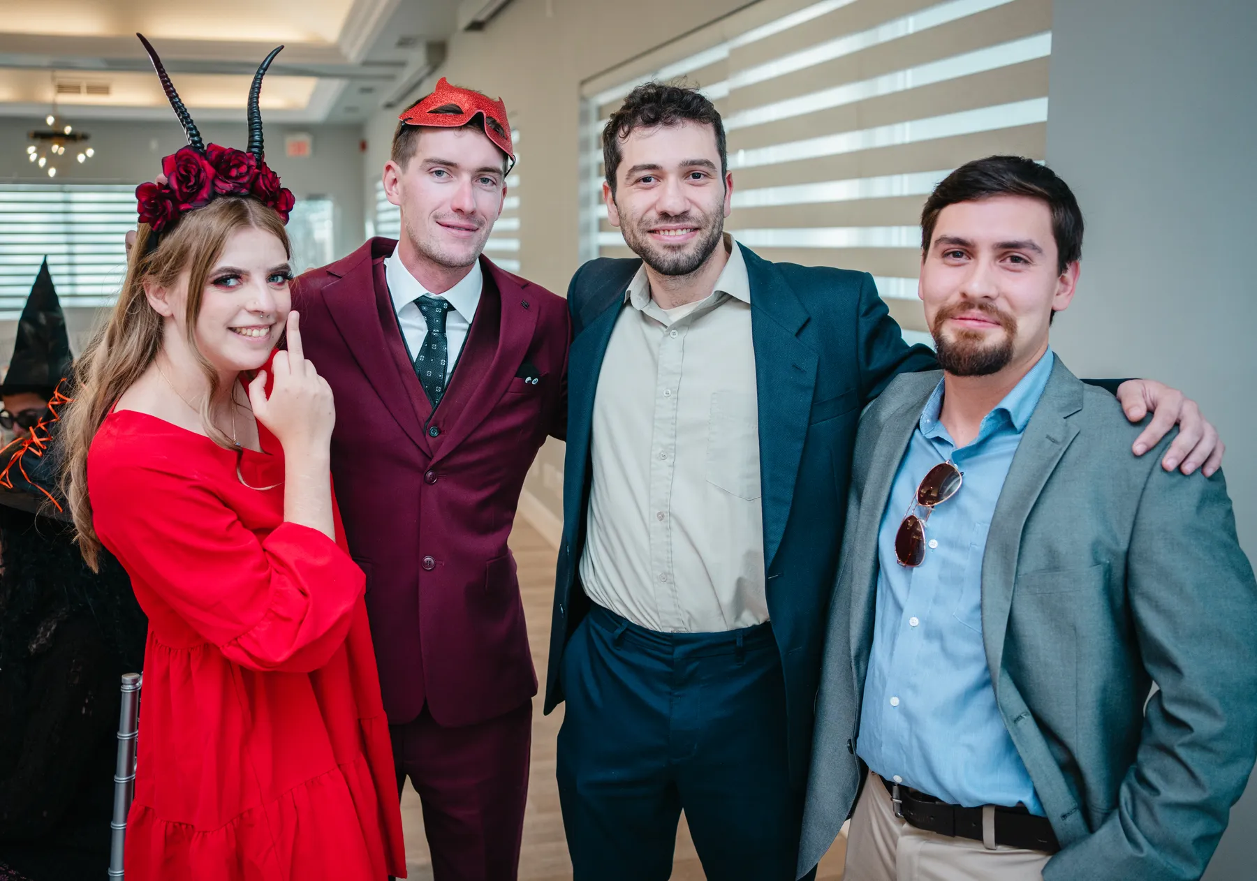 A small group of guests posing indoors at Jenna and Jake’s Halloween party.