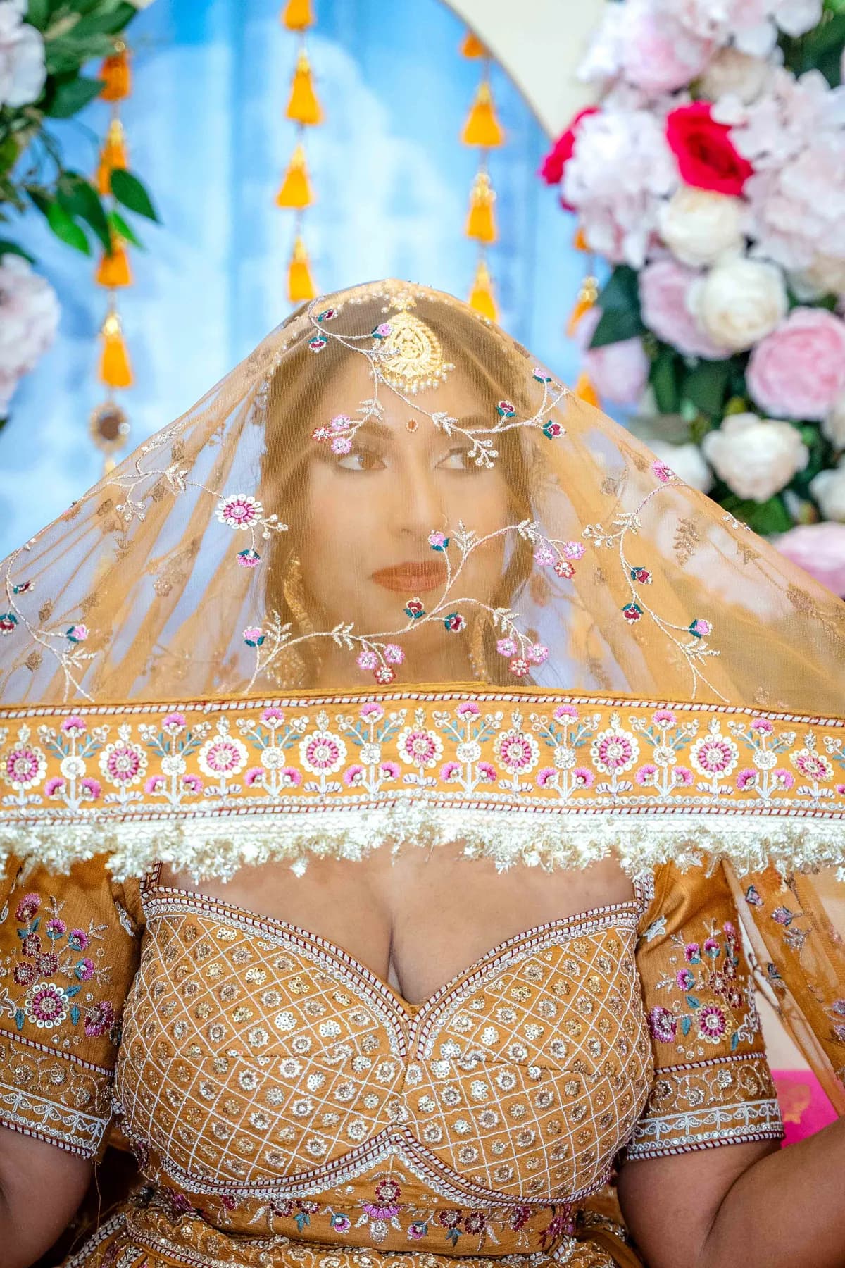 Portraits and outfit details of a woman in gold at Jessie and Erin’s Haldi celebration.