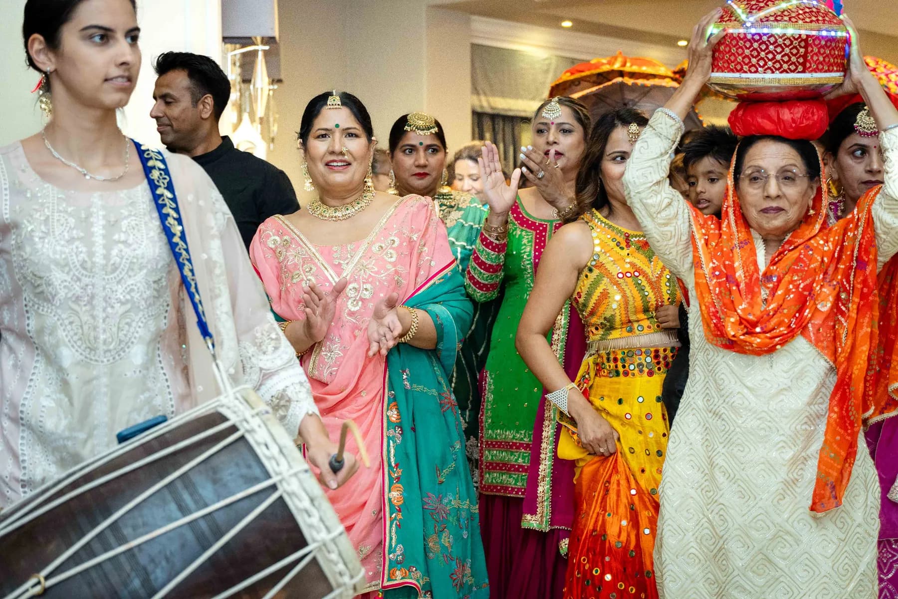 Guests dancing with decorated vessels at Jessie and Erin’s Haldi celebration.