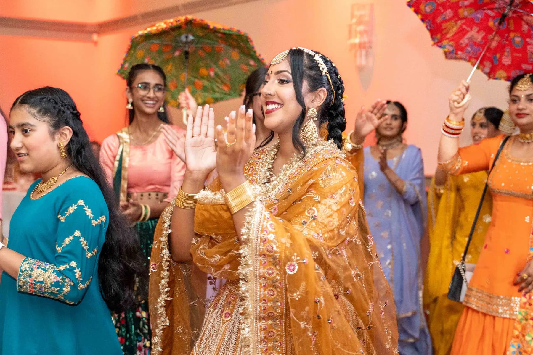 Guests dancing with decorated vessels at Jessie and Erin’s Haldi celebration.