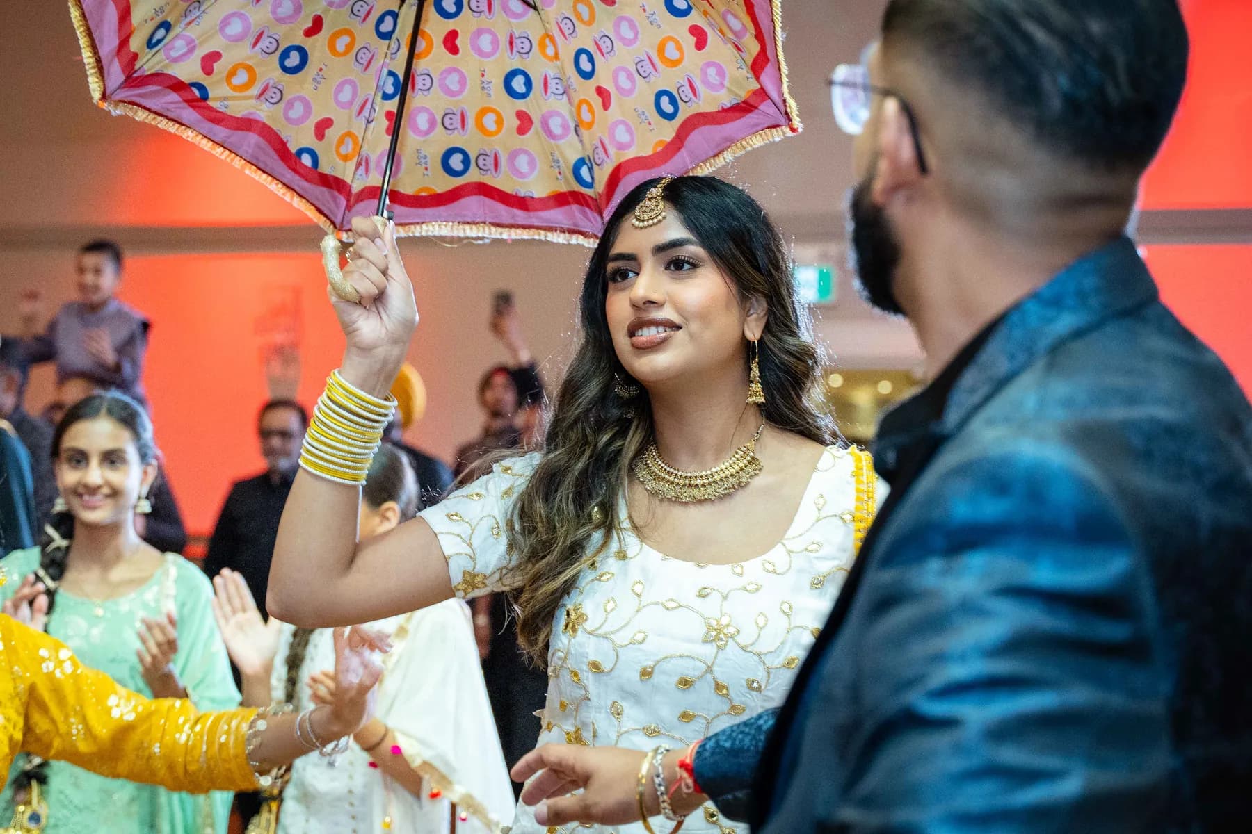Guests dancing with decorated vessels at Jessie and Erin’s Haldi celebration.